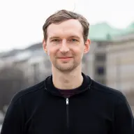 Blonder Mann mit blauem Pulli