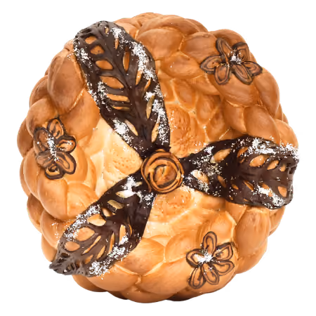 Round braided bread decorated with three dark chocolate or cocoa-dusted leaves and small flower-shaped designs on top.