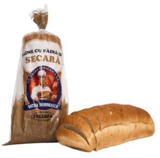 Loaf of sliced rye bread placed next to a brown paper bag of rye flour with Romanian labeling.