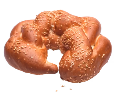 Round braided bread topped with sesame seeds on a white background.