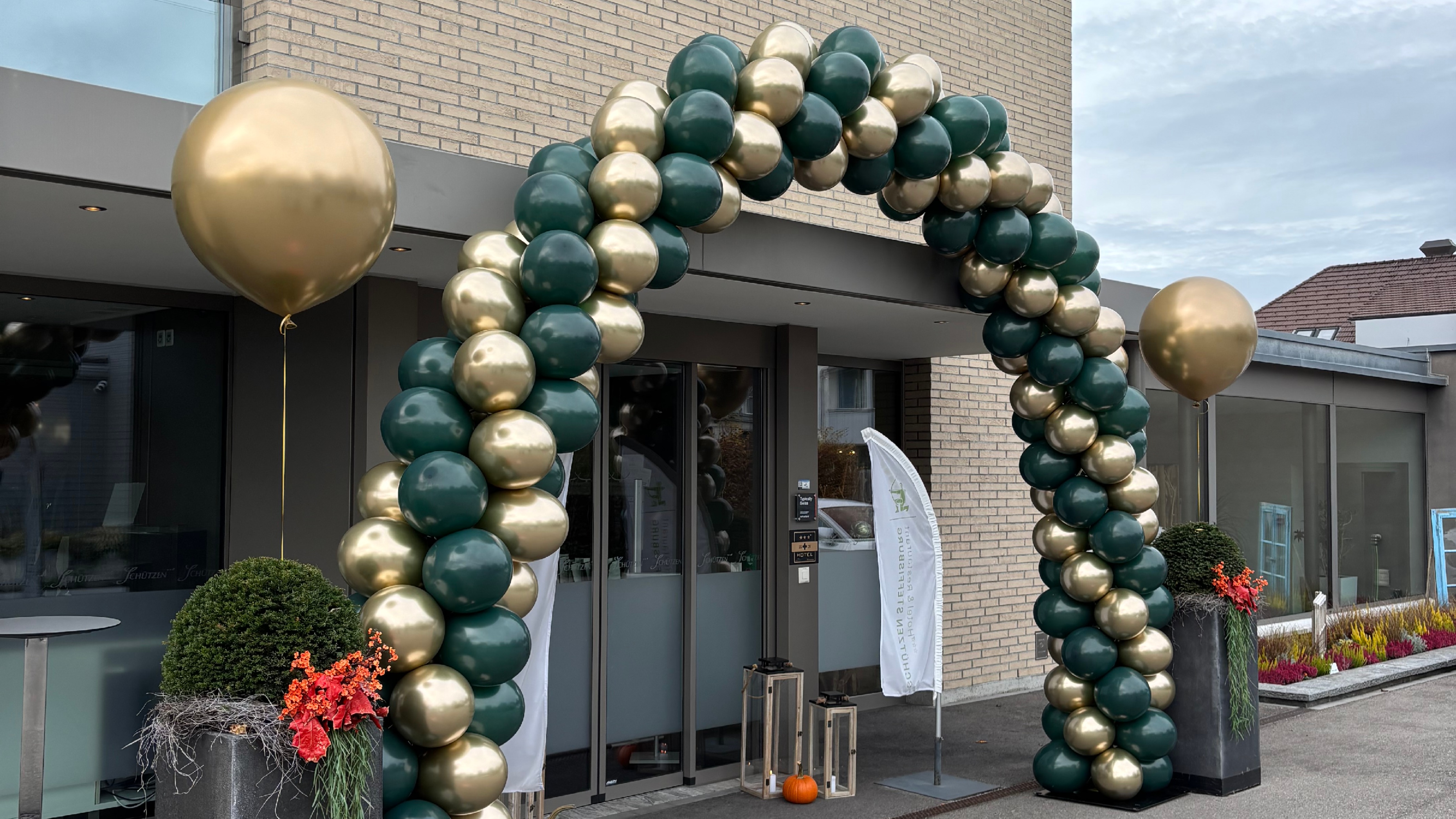 Eingangsbereich des Schützen Steffisburg dekoriert mit einem grossen Ballonbogen in Grün-Gold und festlicher Jubiläumsdekoration