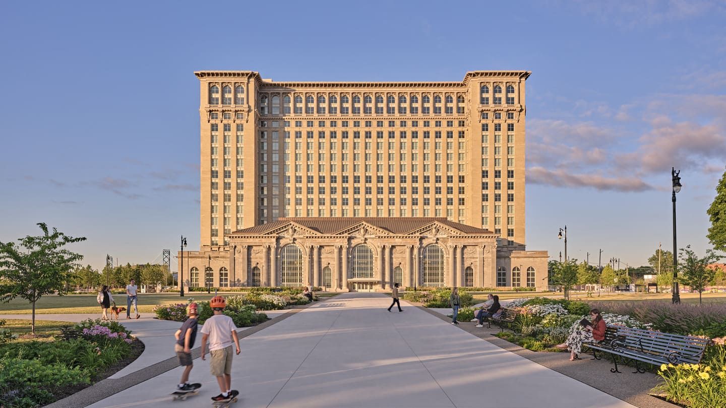 Exterior of a train station with an activated landscape area in front.