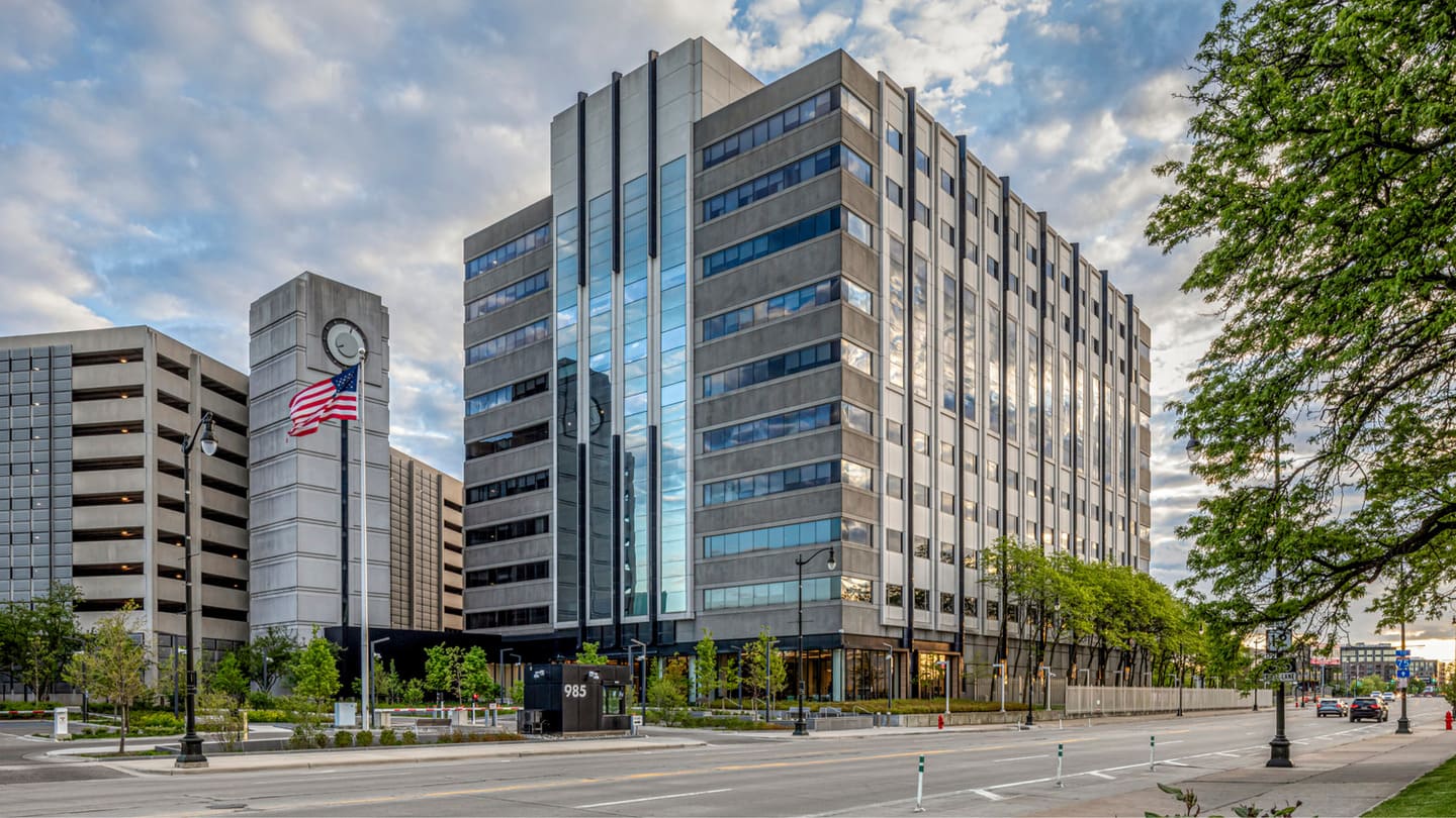 A before-and-after slider of a fenced-off office building and the same building renovated and with no fence.