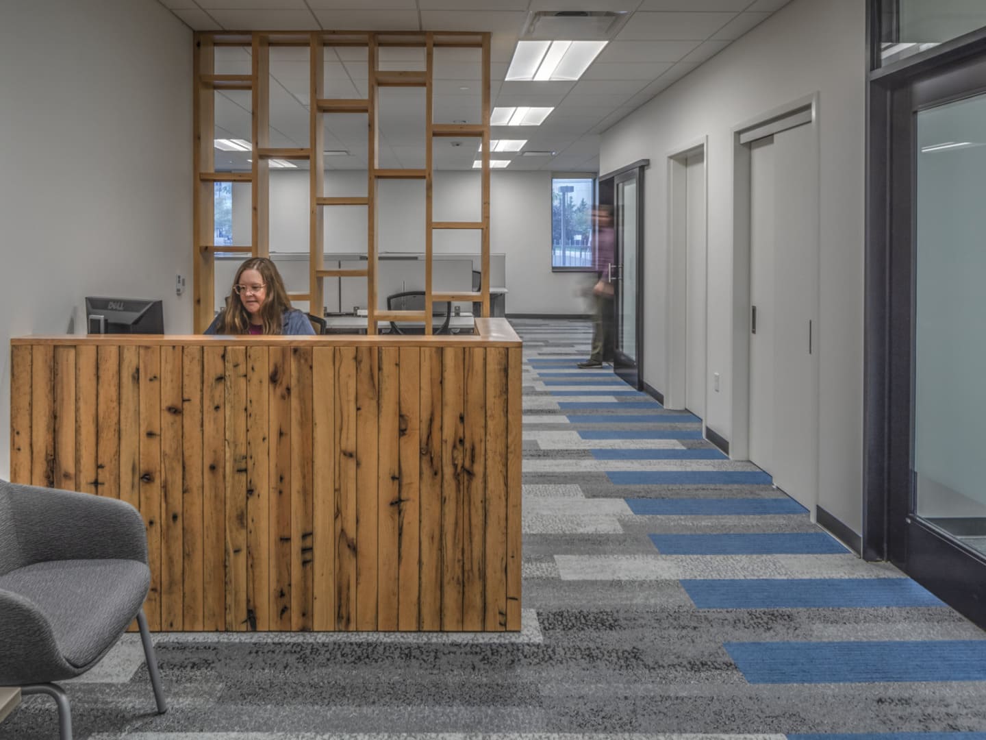 An interior photo of a reception desk made from rustic wood boards.