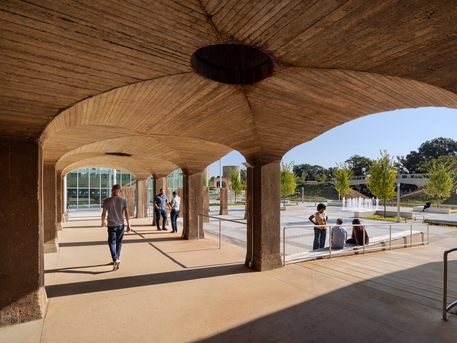 Visitors gather on a walkway by the plaza.