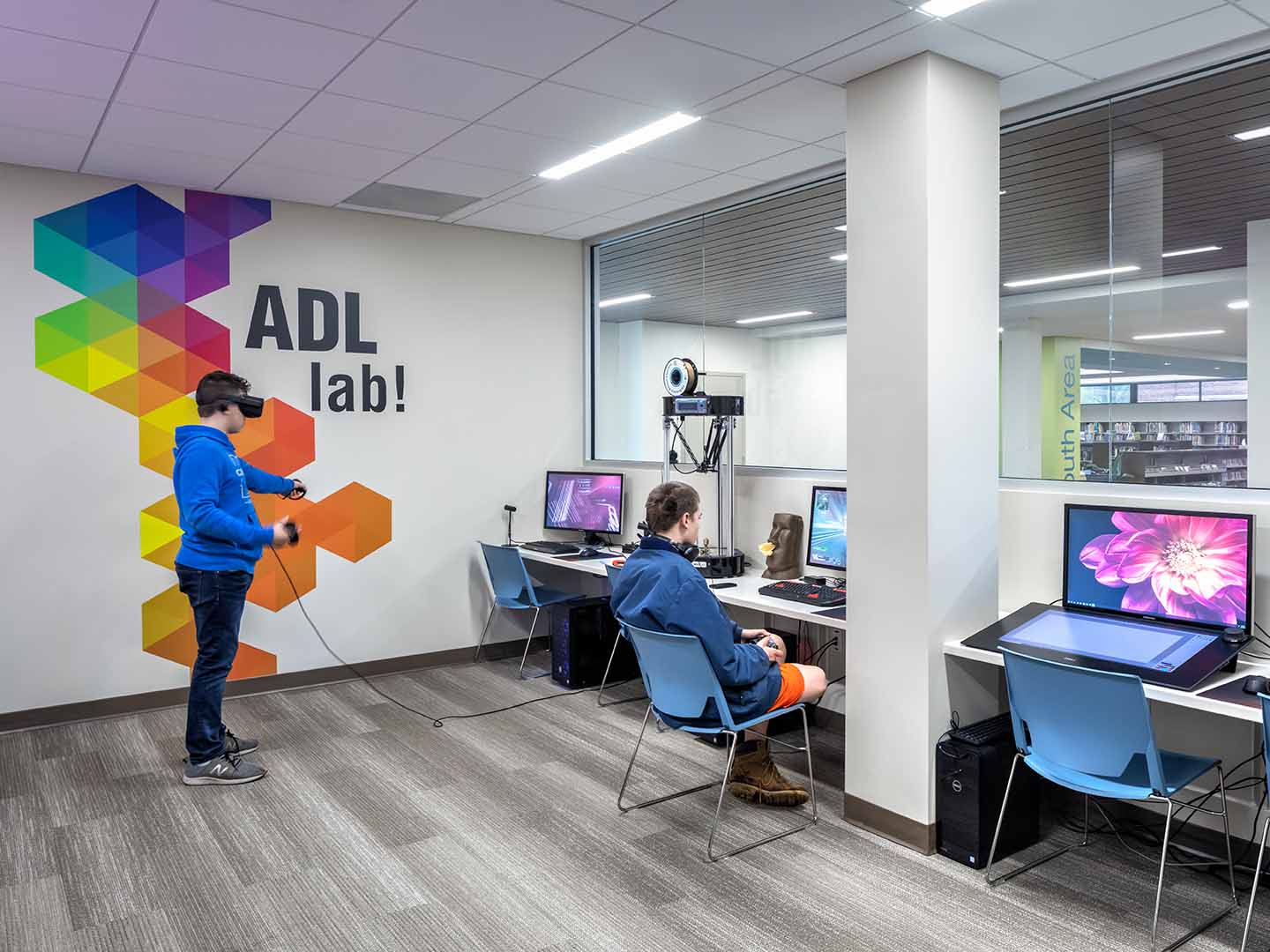 A photo of users experiencing the ADL lab. One child is playing with a virtual reality interface.