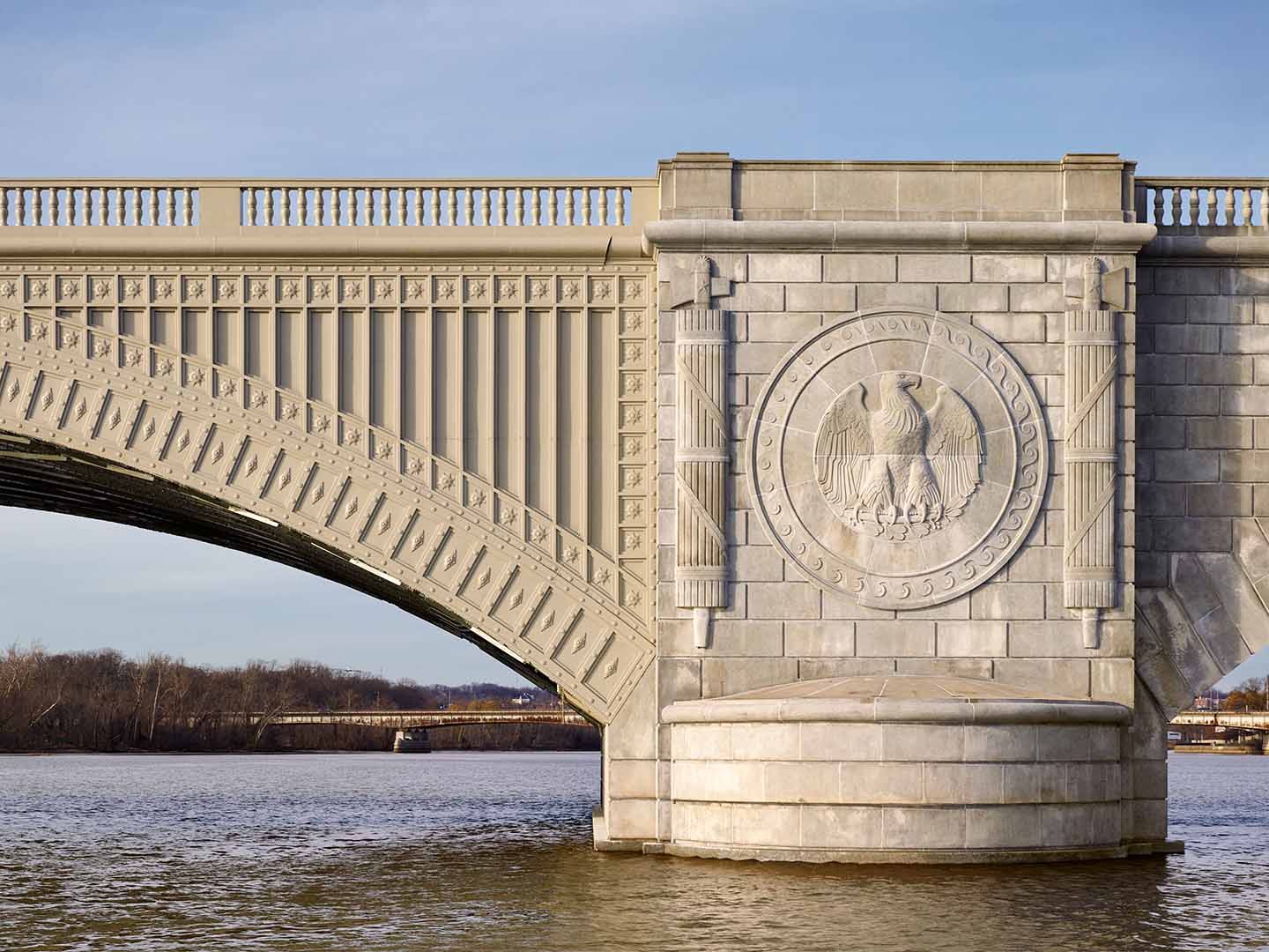 A detail photo of the side of Arlington Memorial Bridge showing an embossed eagle seal on the bridge's pillar.