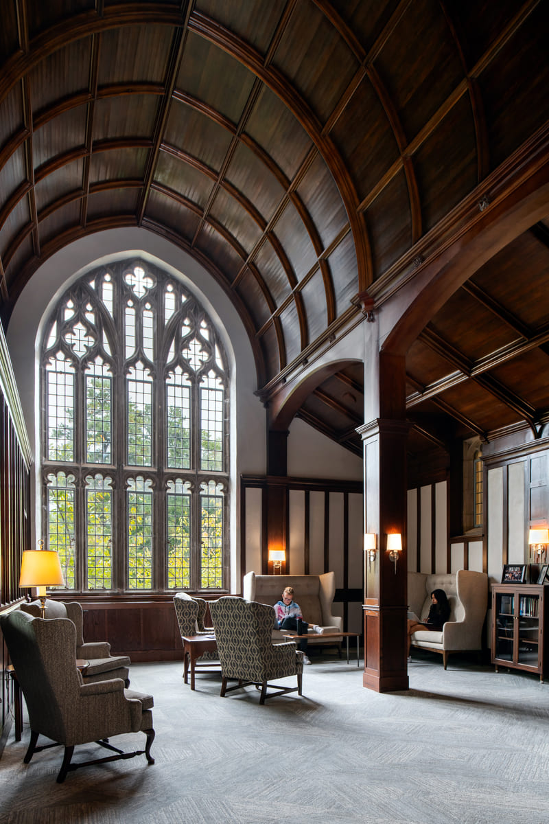 A photo of a large gothic style window in a reading room.