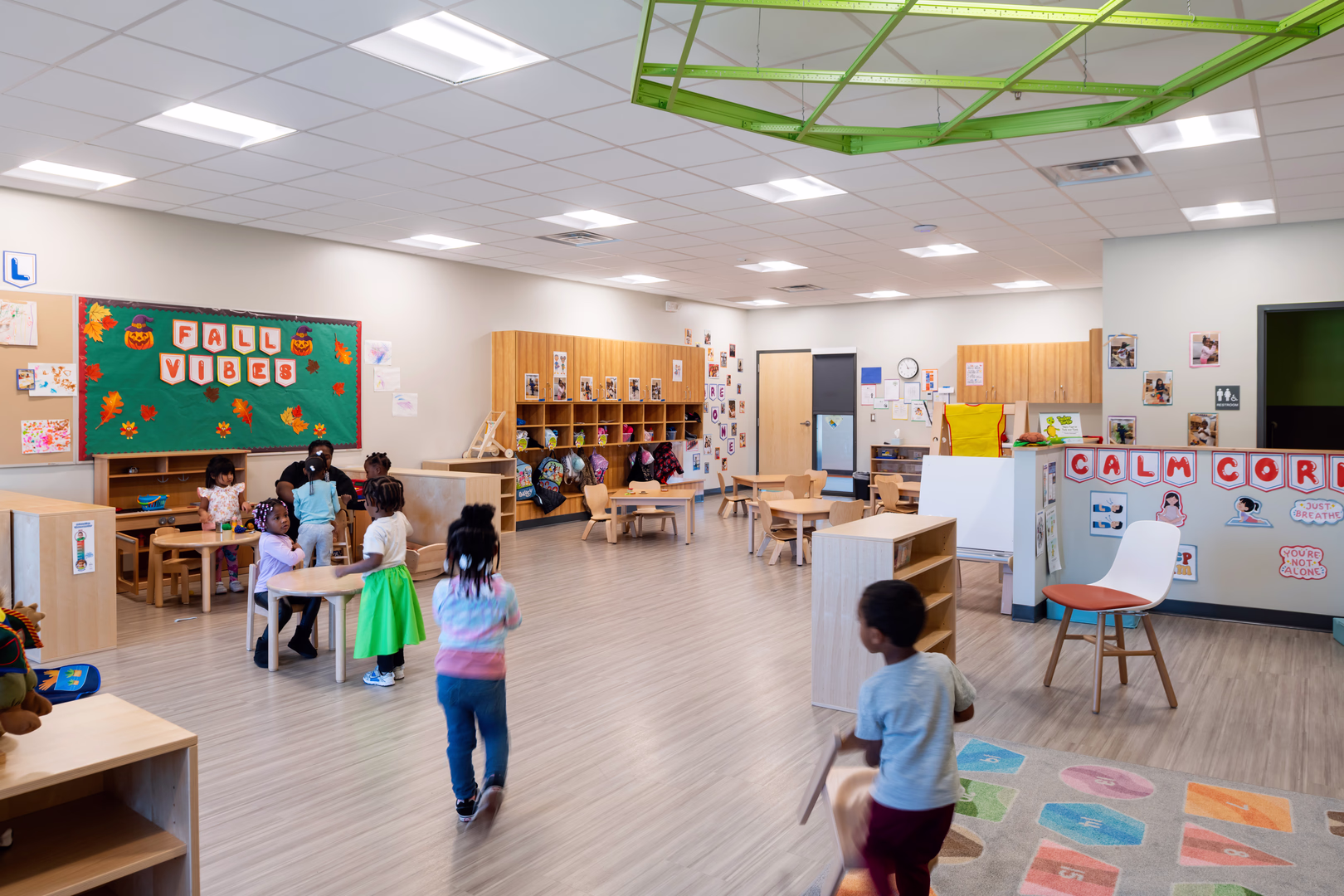 A preschool classroom with students engaged in different activities.