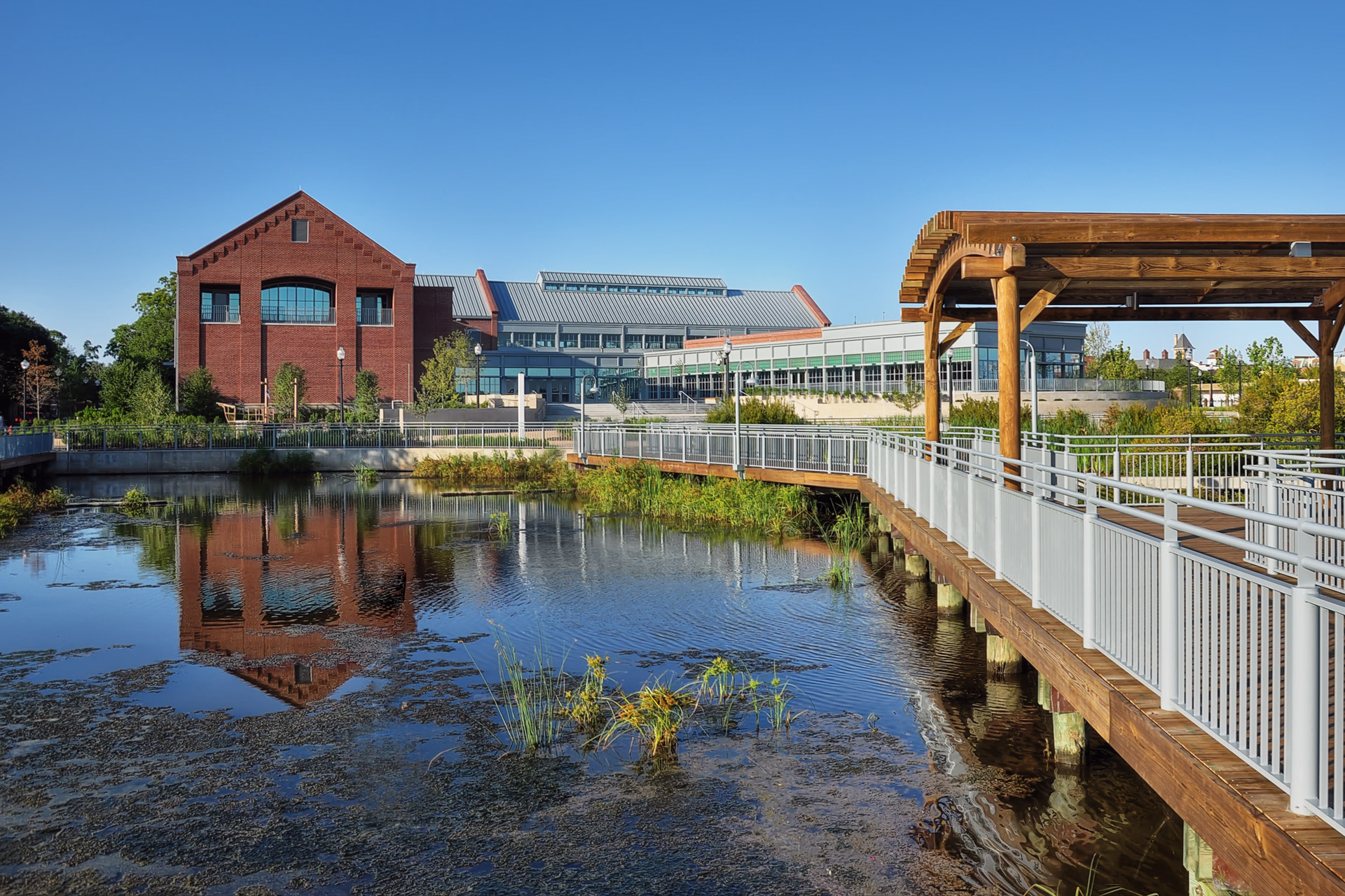 An exterior photo looking across a wetland to a red brick museum building.