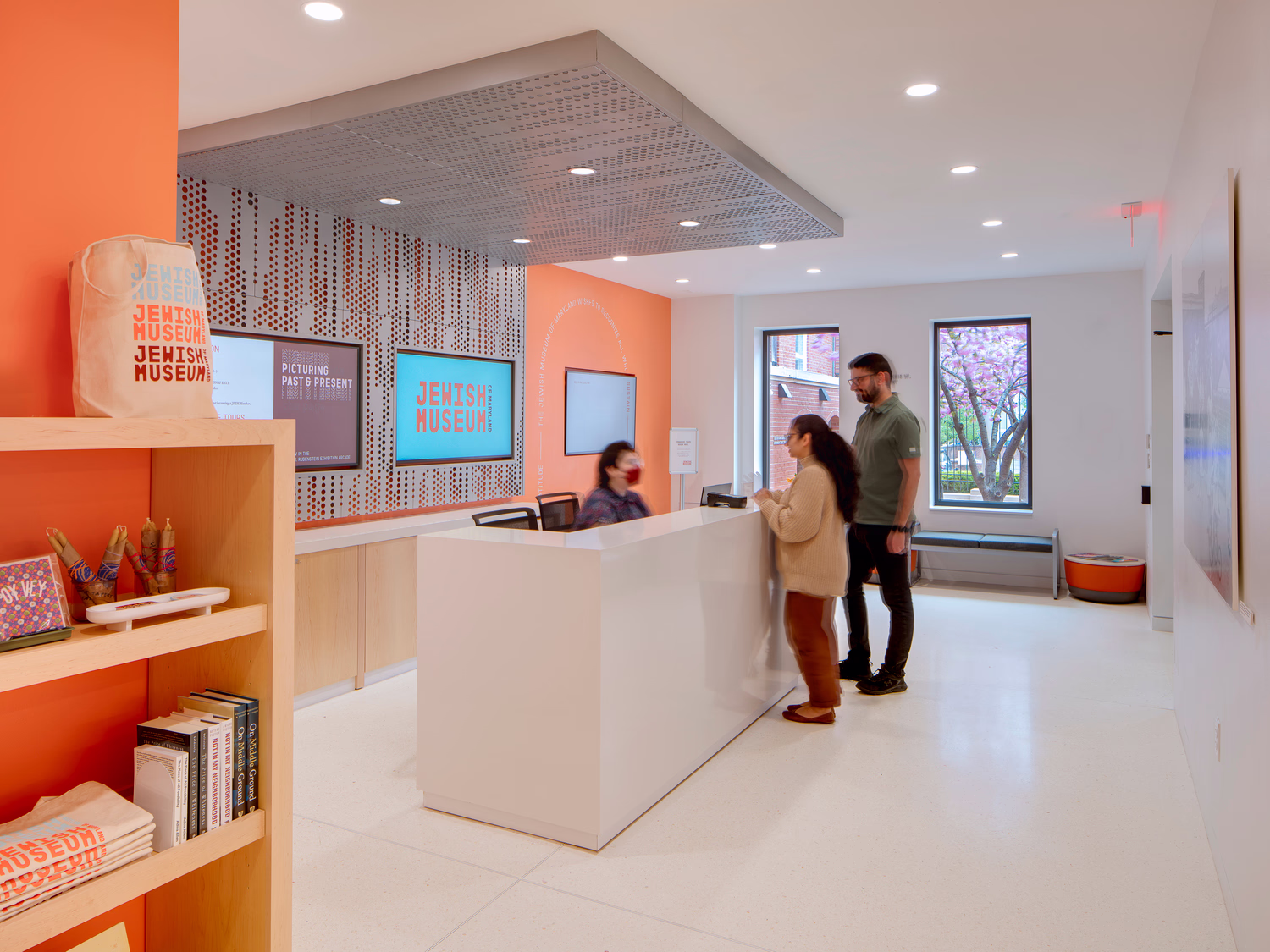 An interior photo of a museum lobbywith people buying tickets at the reception desk.