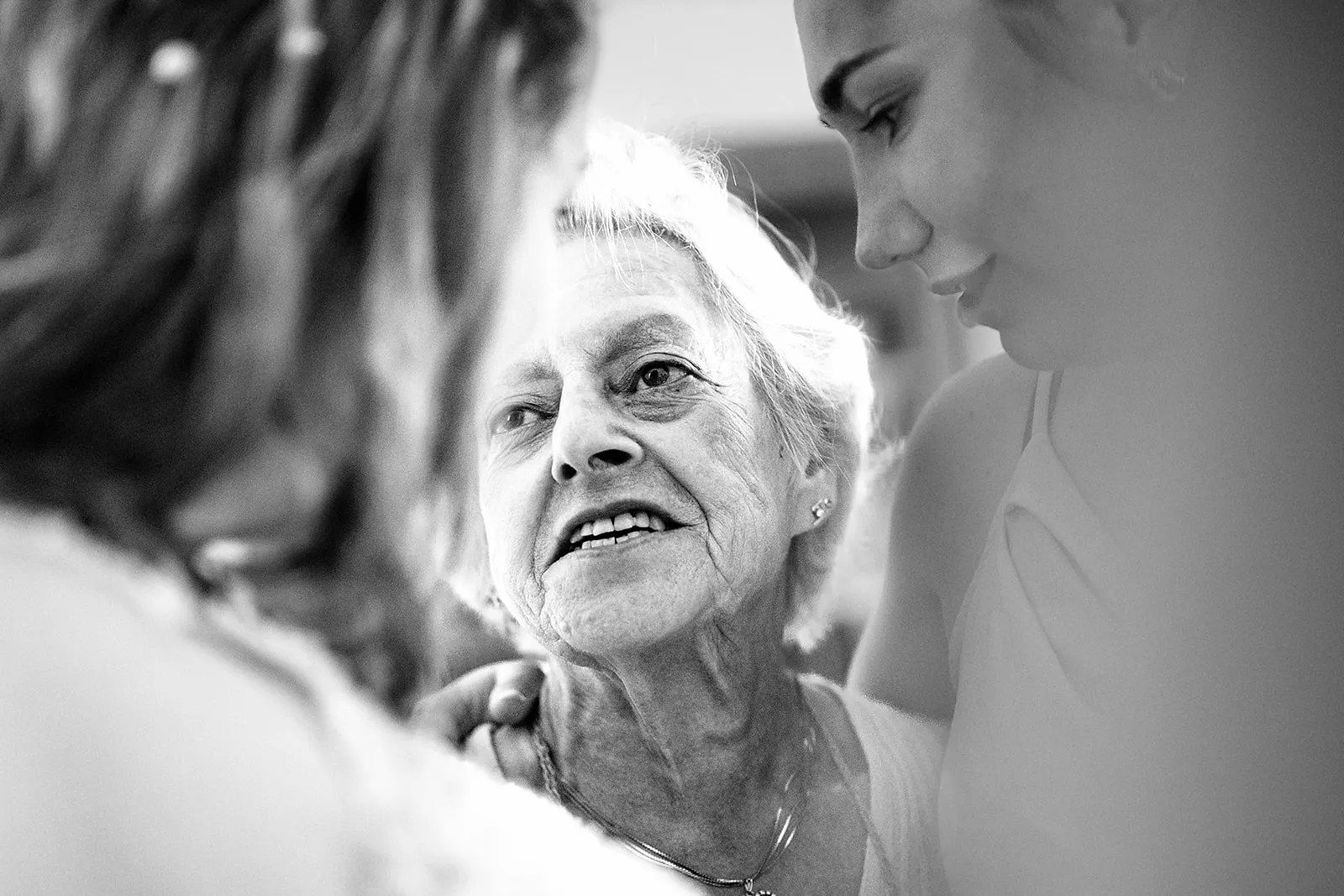 oma kijkt liefdevol naar bruid bij proost bruidspaar
