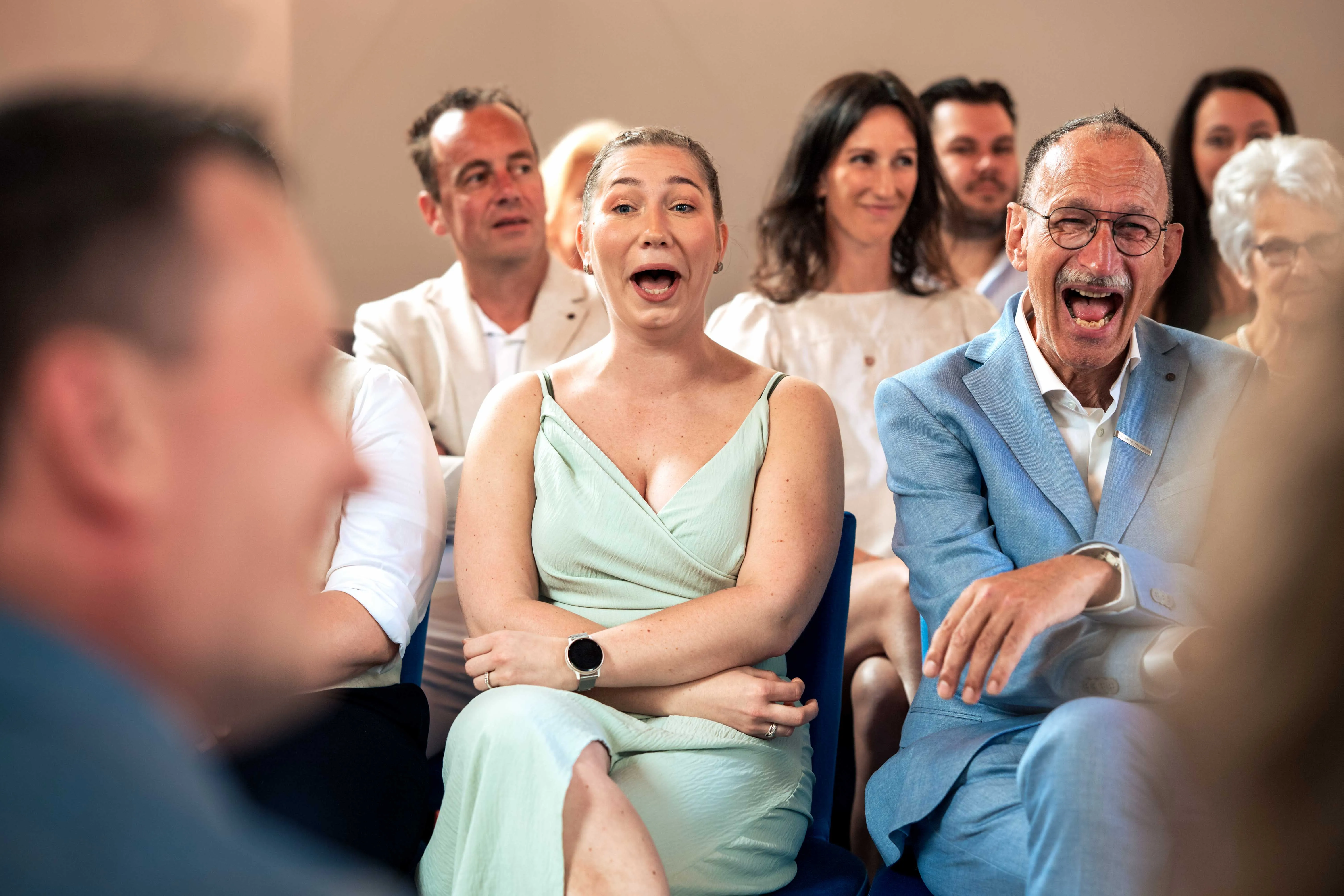 vrienden tijdens ceremonie lachen bruidspaar