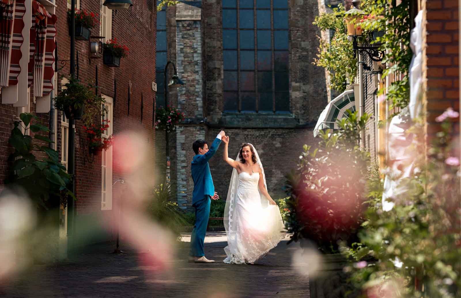 bruidspaar doet een dans tijdens de fotoshoot trompetstraat delft