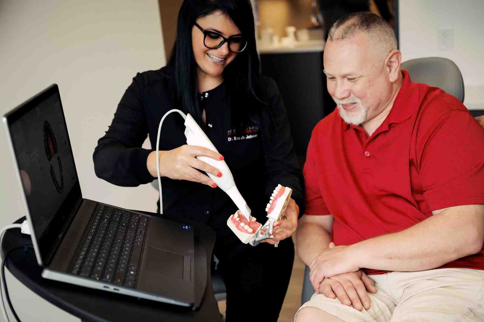 dentist and patient discussing crown options with a tooth model - dental crown materials