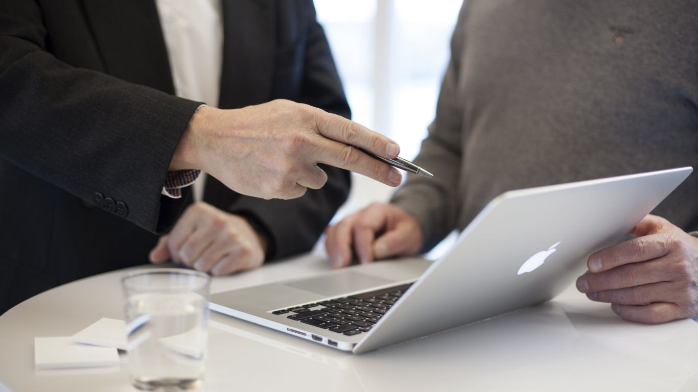 Zwei Personen in einer Besprechung, die gemeinsam Daten auf einem Laptop analysieren, repräsentierend die Unternehmensberatung von Kohnle & Partner.