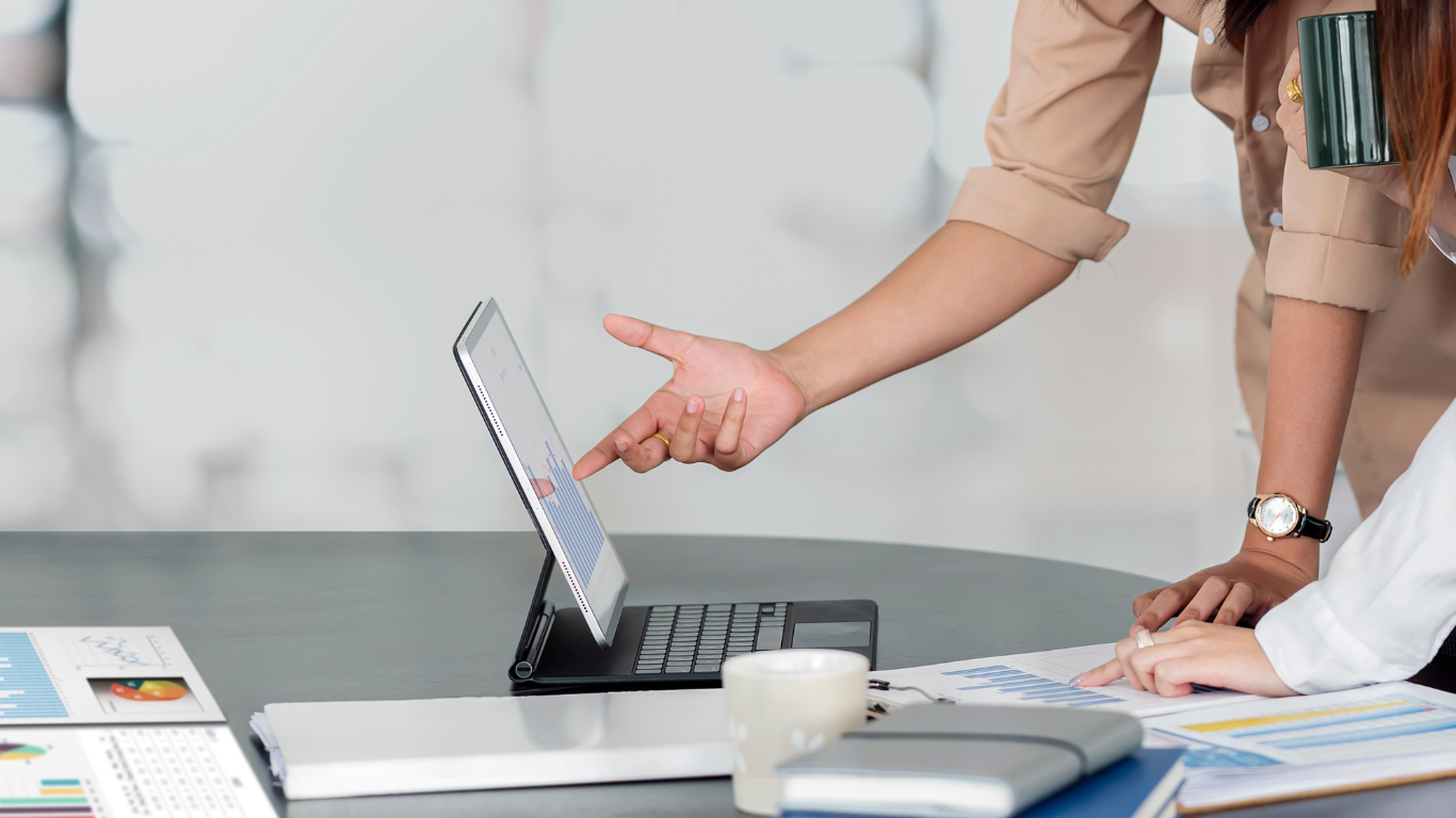 Personen besprechen Finanzanalysen an einem Laptop, passend zum Thema 'Finanzen' von Kohnle & Partner.