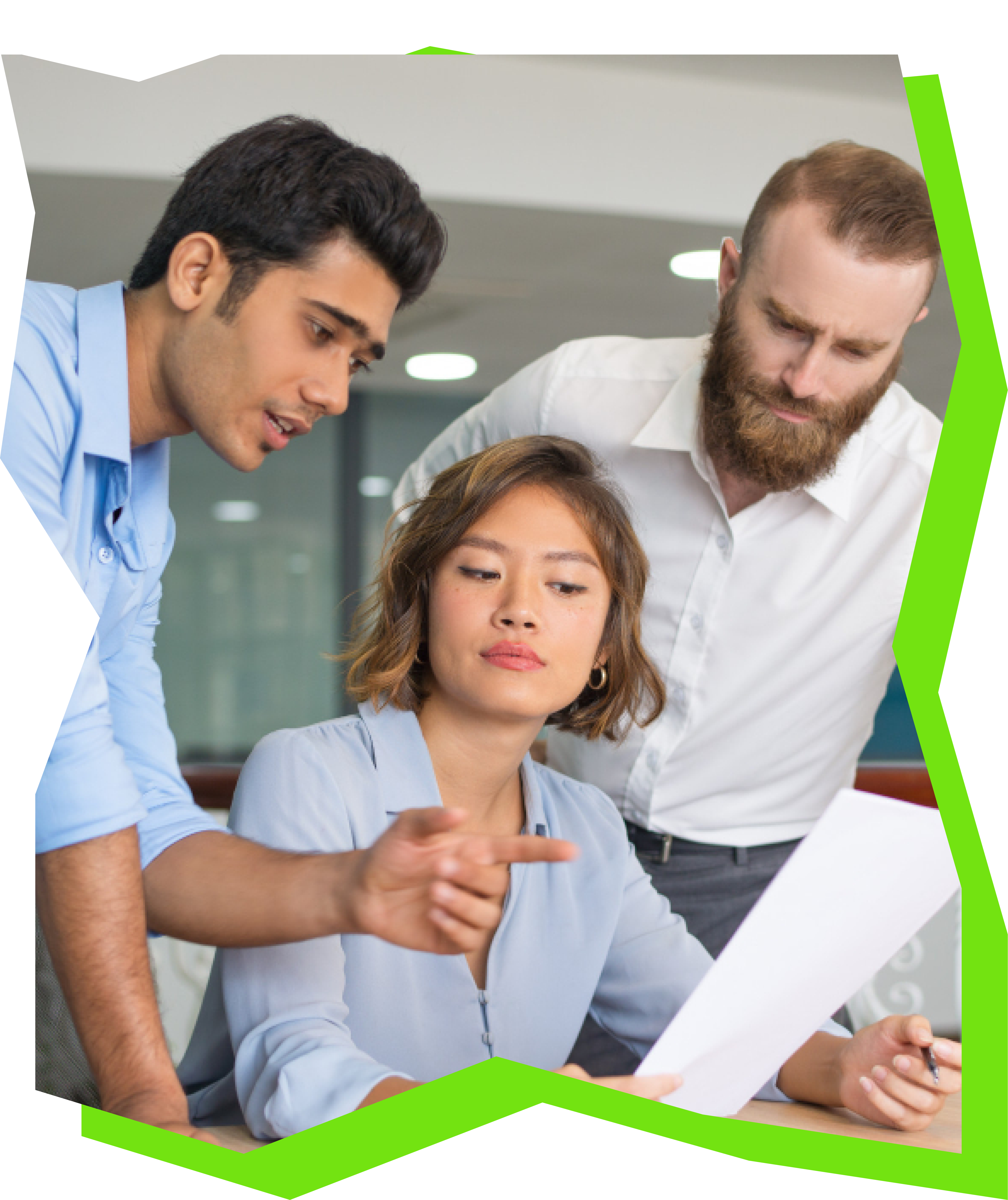 Three colleagues in an office reviewing a document together, one pointing while others look at the paper.
