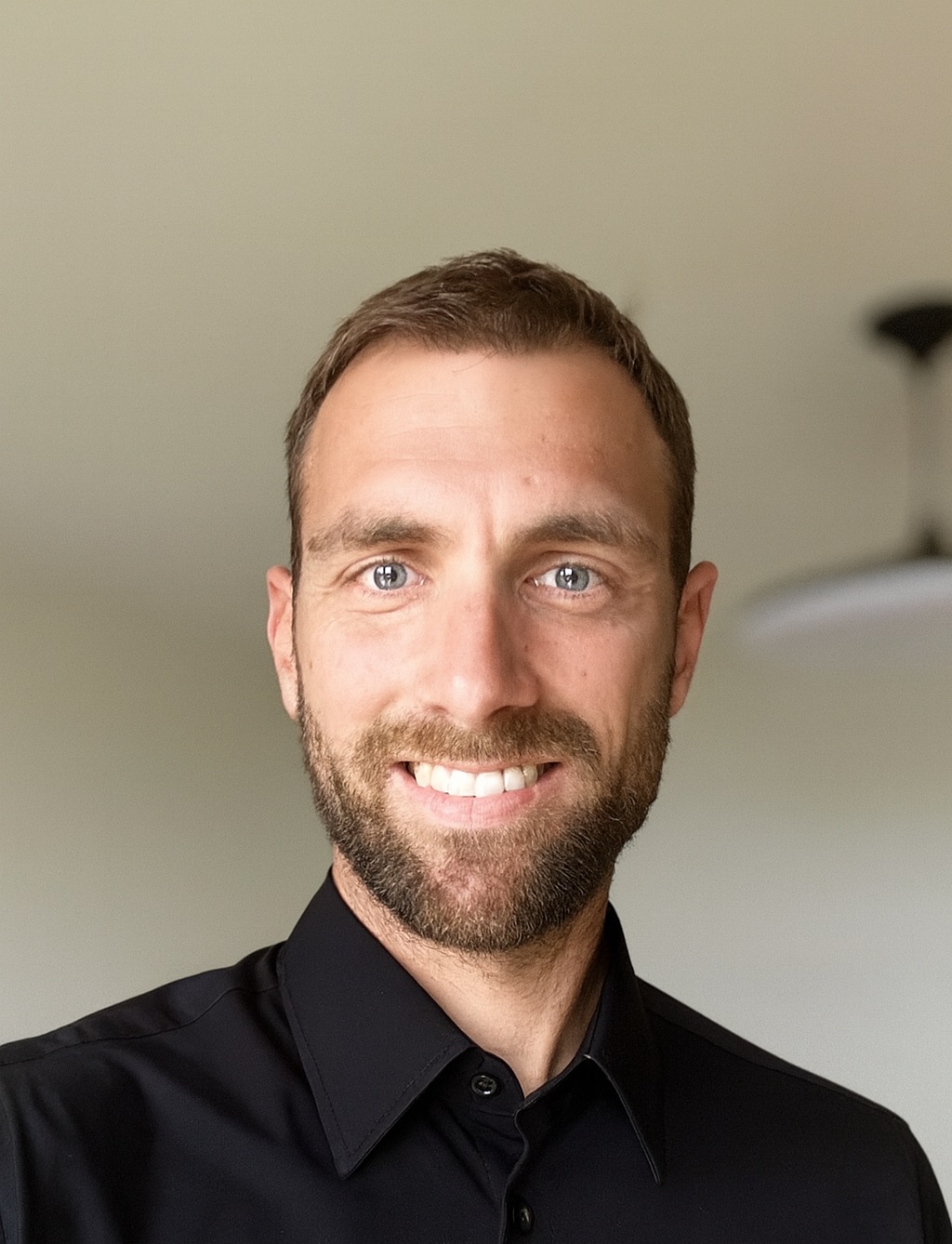 Foto von Lucien Perisset, Operations & Customer Support Manager bei droople in grauem T-Shirt auf schwarzem Hintergrund