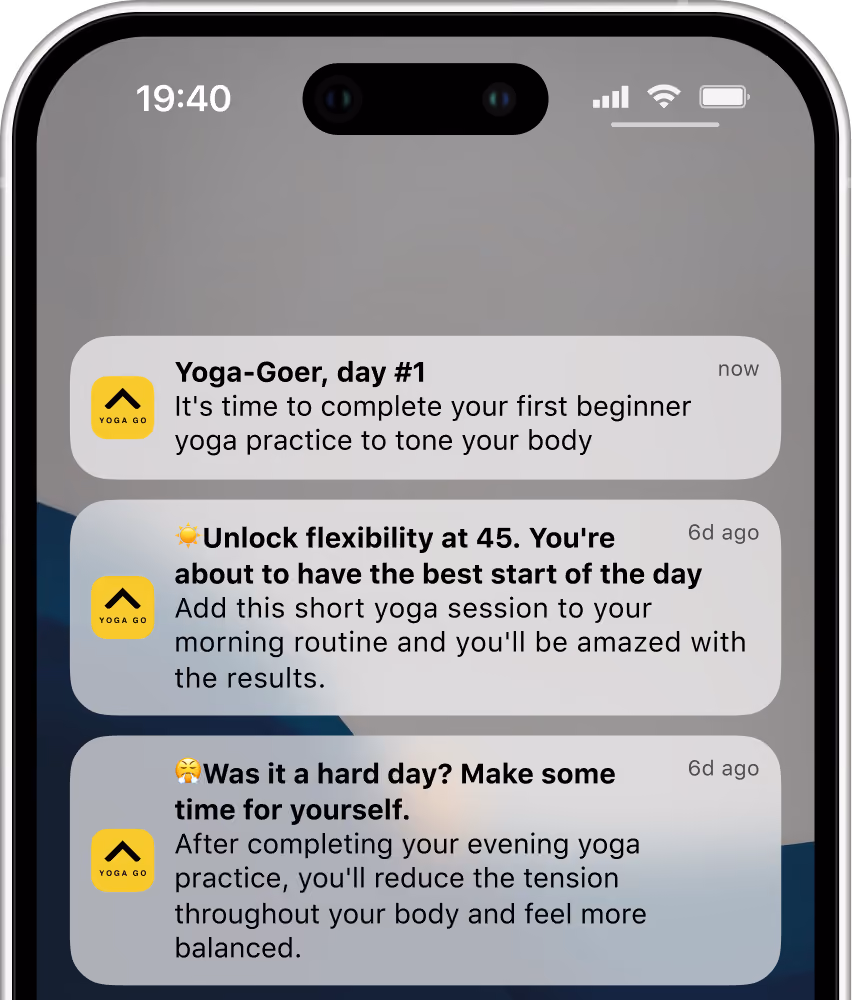 Smartphone screen showing three notifications from Yoga Go app about yoga practice. The first says, 'Yoga-Goer, day #1: It's time to complete your first beginner yoga practice to tone your body.' The second says, 'Unlock flexibility at 45. You're about to have the best start of the day. Add this short yoga session to your morning routine and you'll be amazed with the results.' The third says, 'Was it a hard day? Make some time for yourself. After completing your evening yoga practice, you'll reduce tension and feel more balanced.'