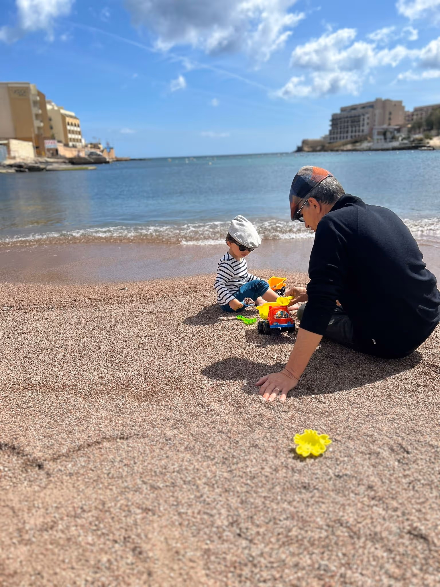 Child and Grandfather playing on the beach