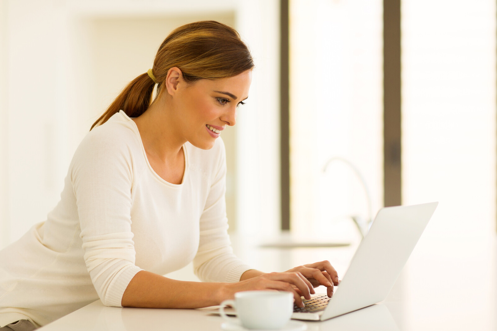 Image showing a woman using a computer. Photo represents User Experience (UE) and User Interface (UI) and how we maximize these for the best user experience.