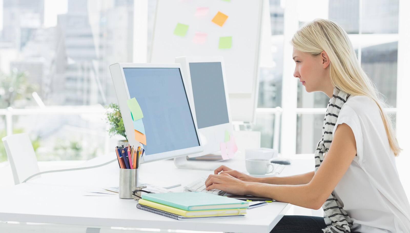 Image of a woman at a desk on a computer representing Engagement Metrics, which analyze user sessions.