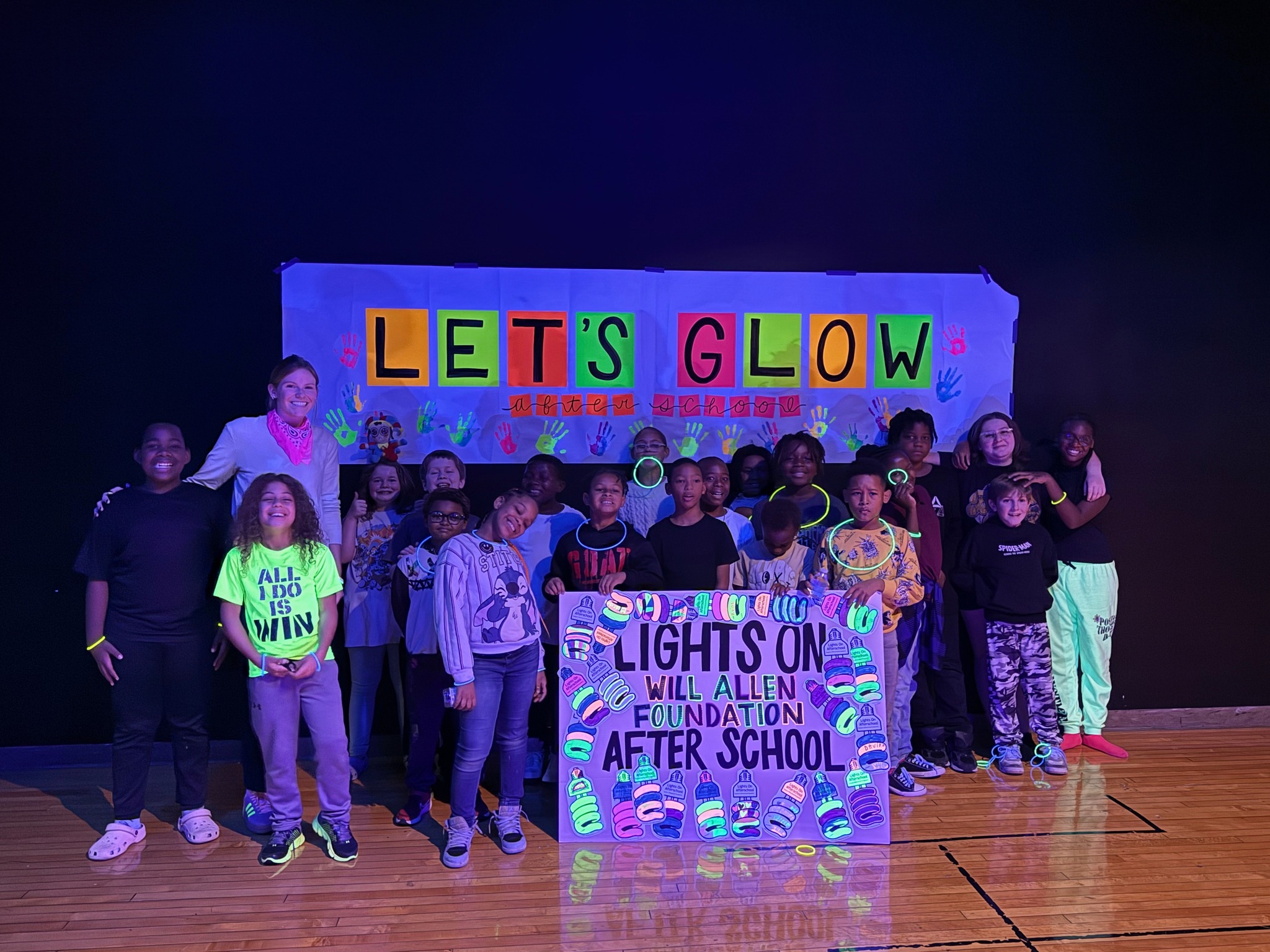 Students holding a sign they made at the Lights On Afterschool Glow Day Celebration