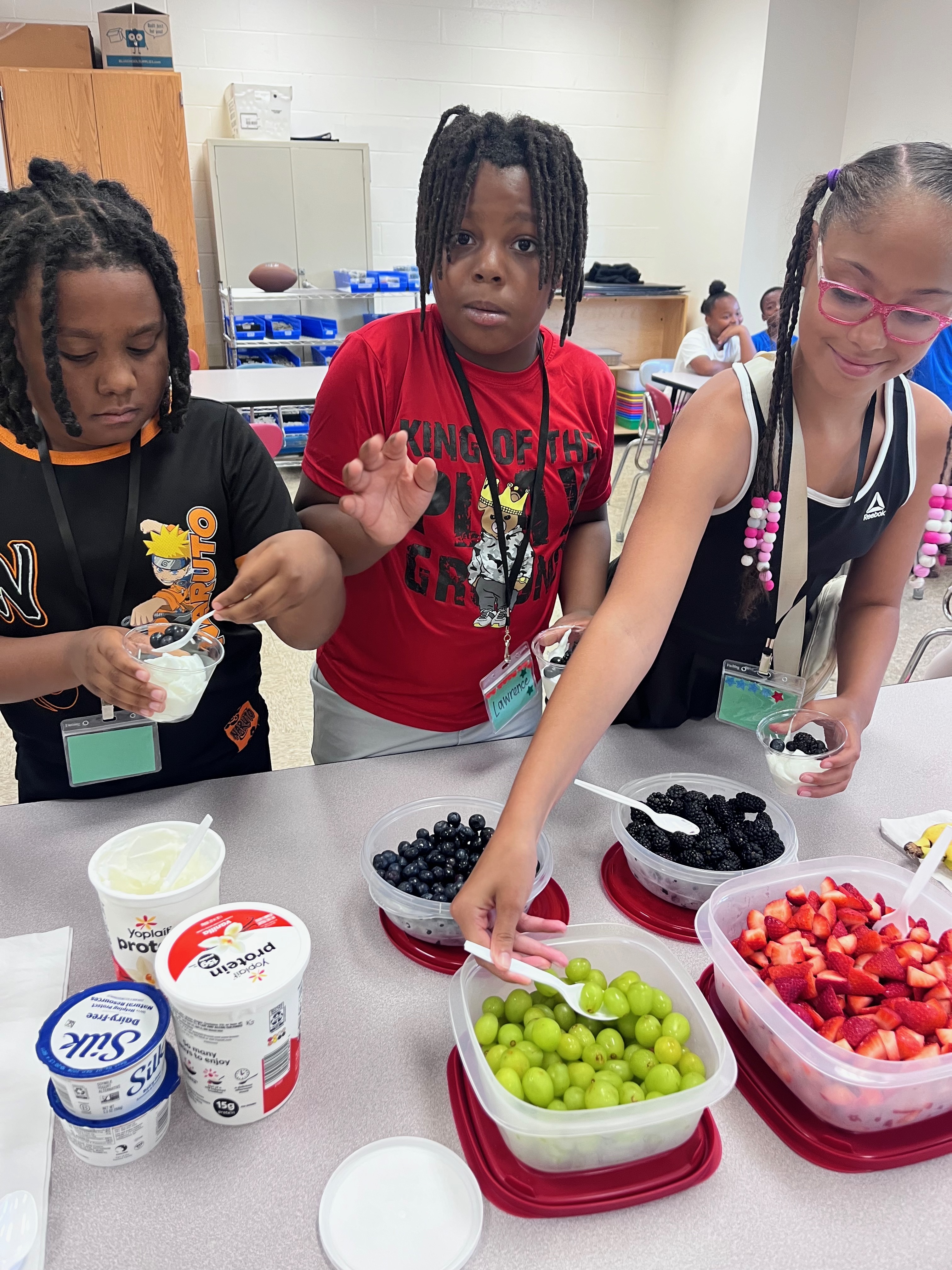 Clairton students making parfaits with fresh fruit and yogurt.