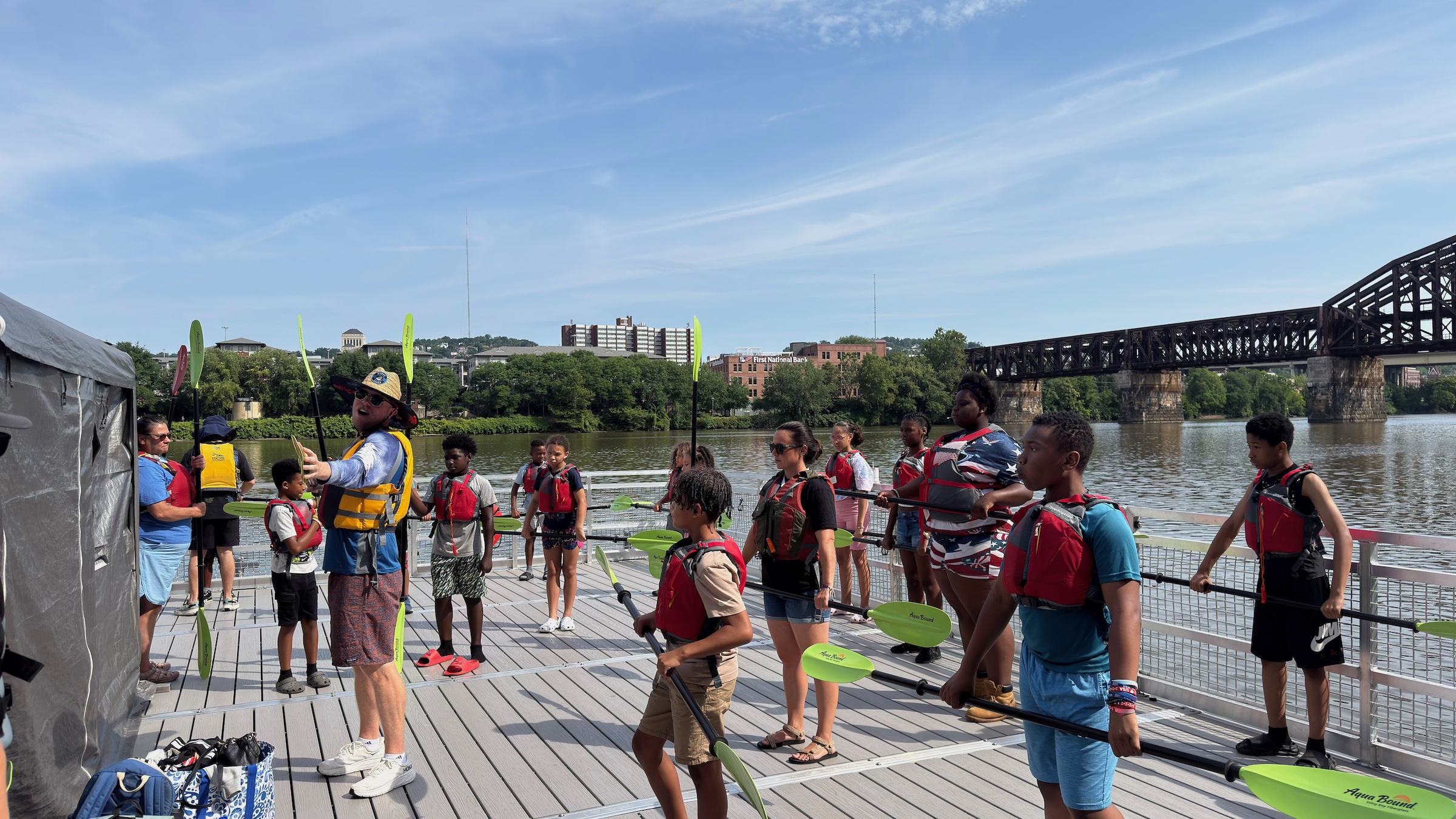 A Venture Outdoors employee shows students how to paddle a kayak.