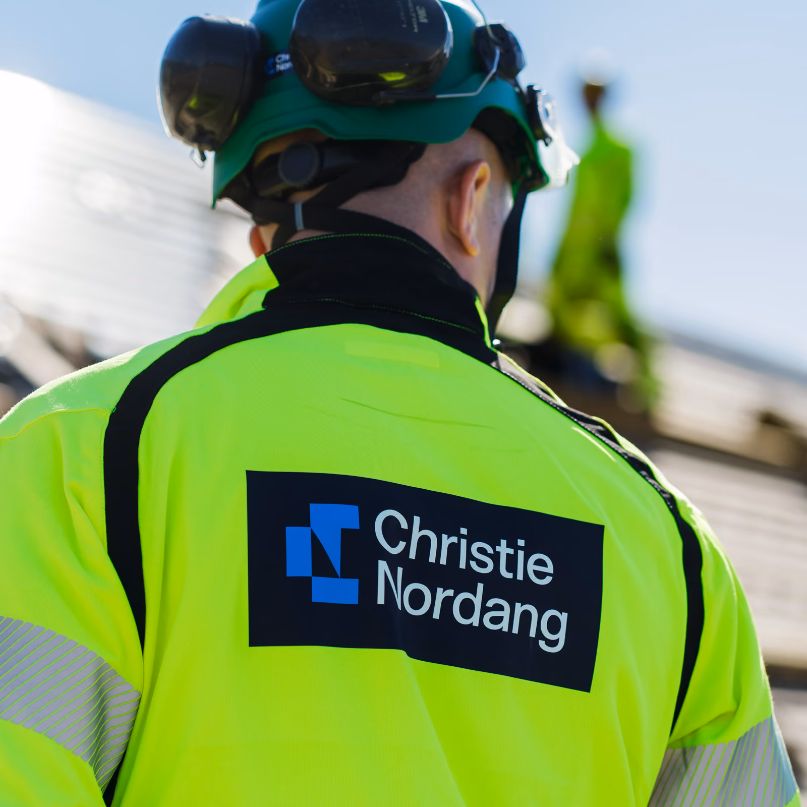 Logo på ryggen til en ansatt på byggeplass.