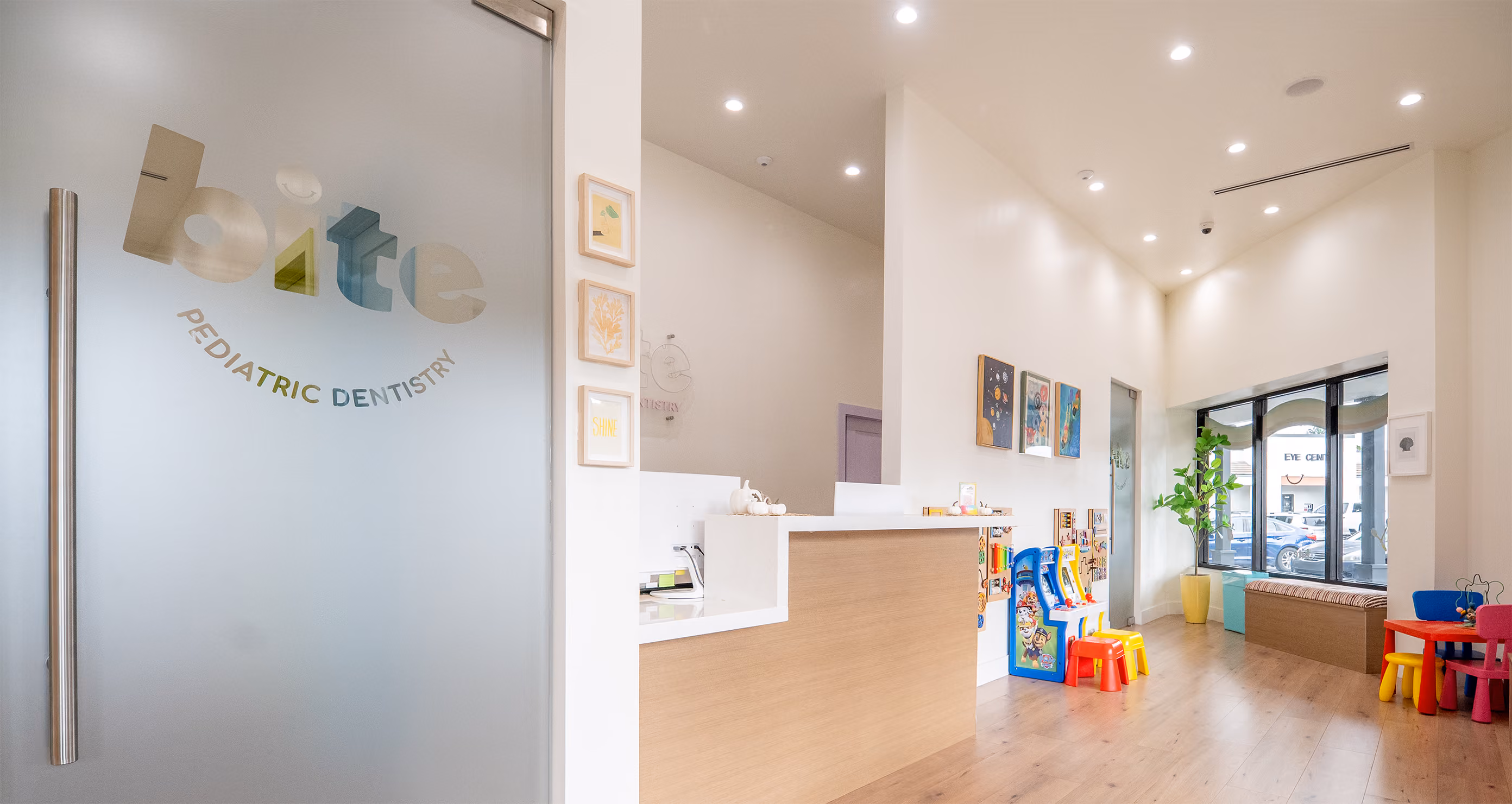 Bright pediatric dentistry waiting room with children’s toys, colorful chairs, and reception desk.