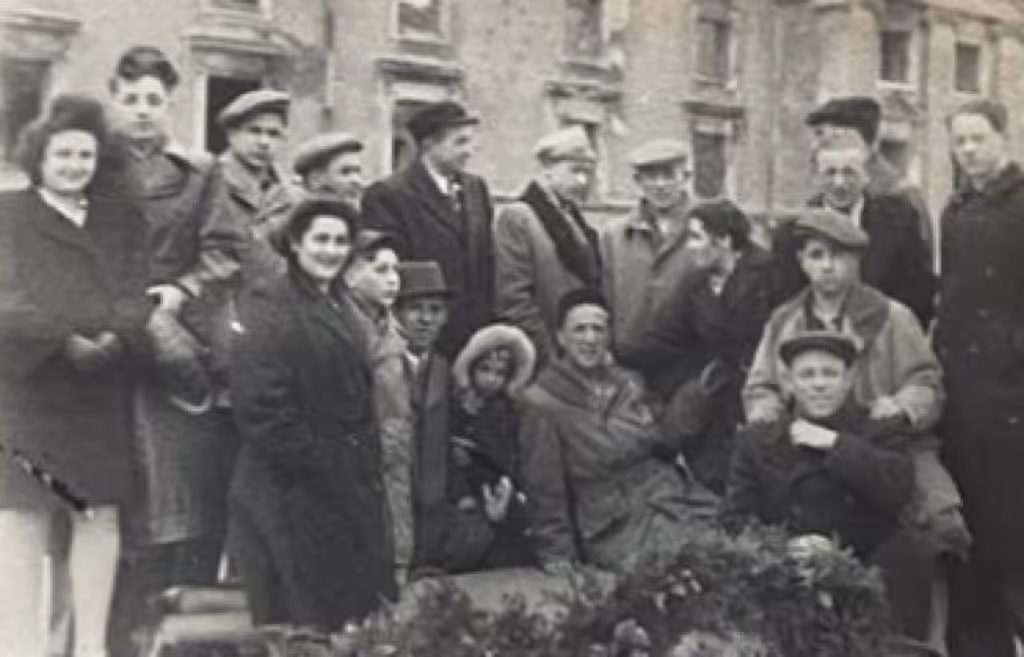 עקיבא (שורה למעלה שלישי משמאל) ואשר (שורה למטה שני משמאל) בגטו ורשה אחרי המלחמה