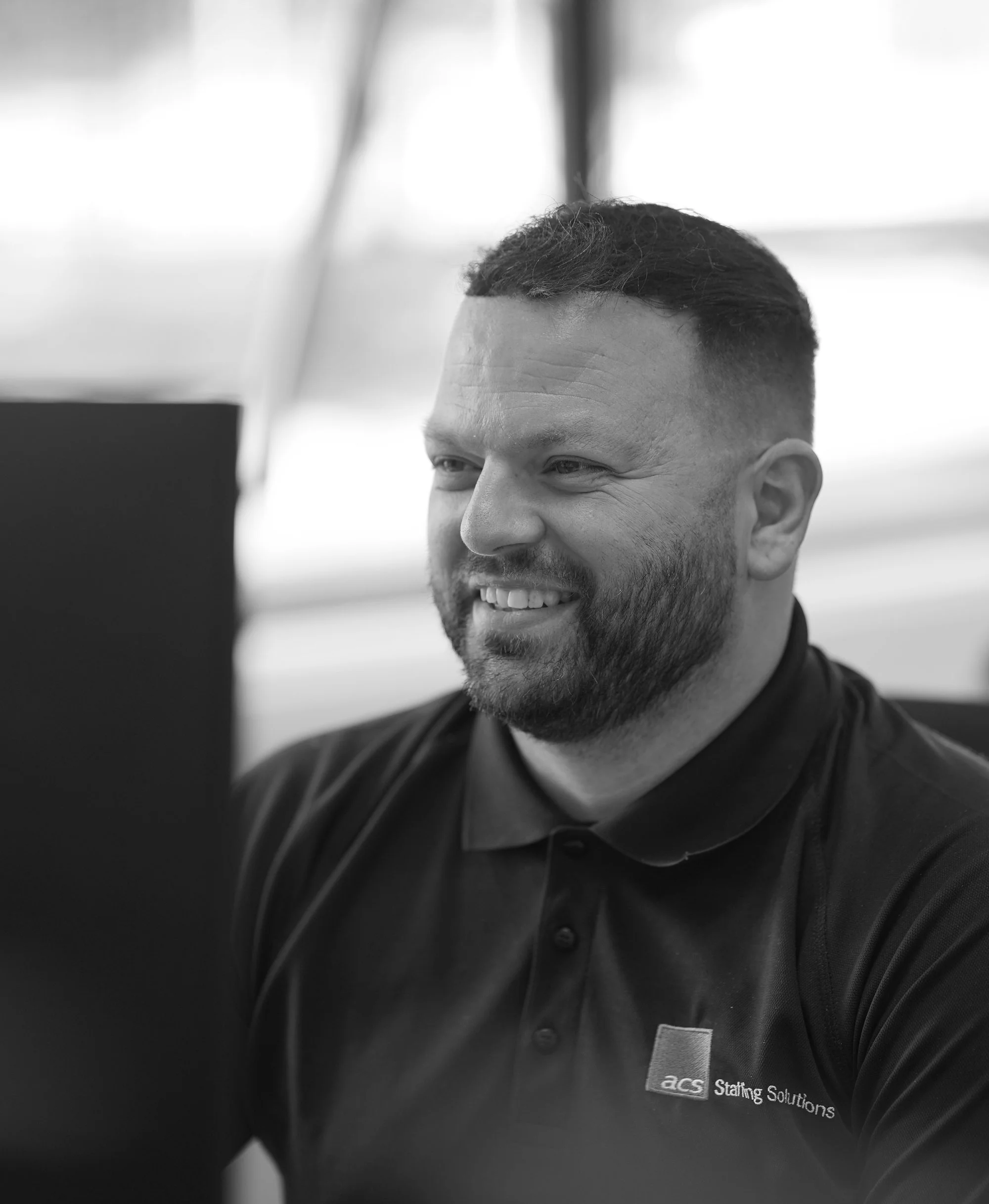 ACS employee man smiling at screen