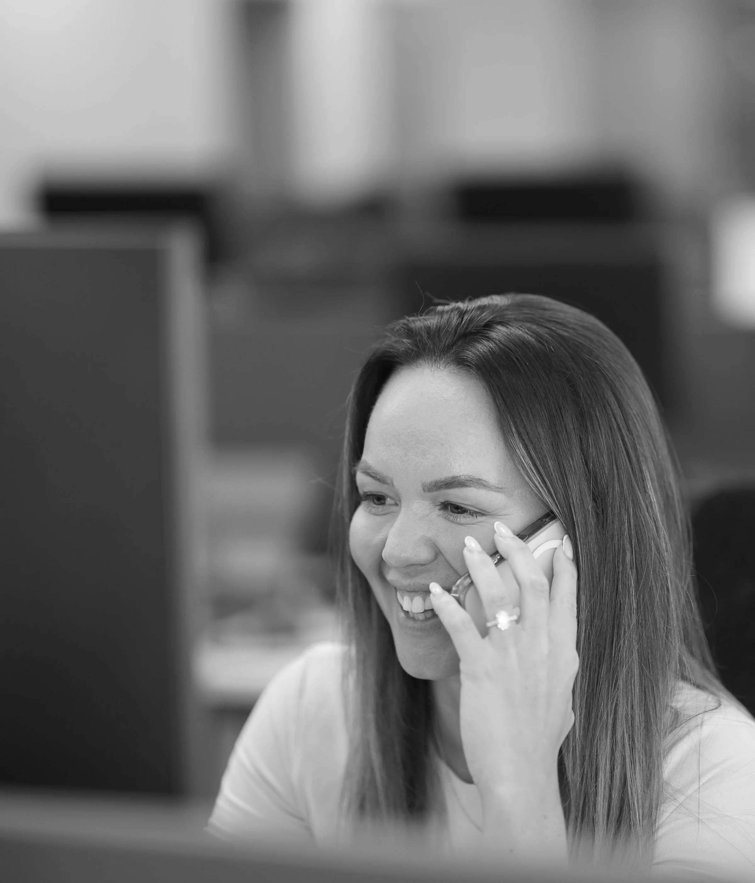 ACS employee woman holding mobile phone smiling while working