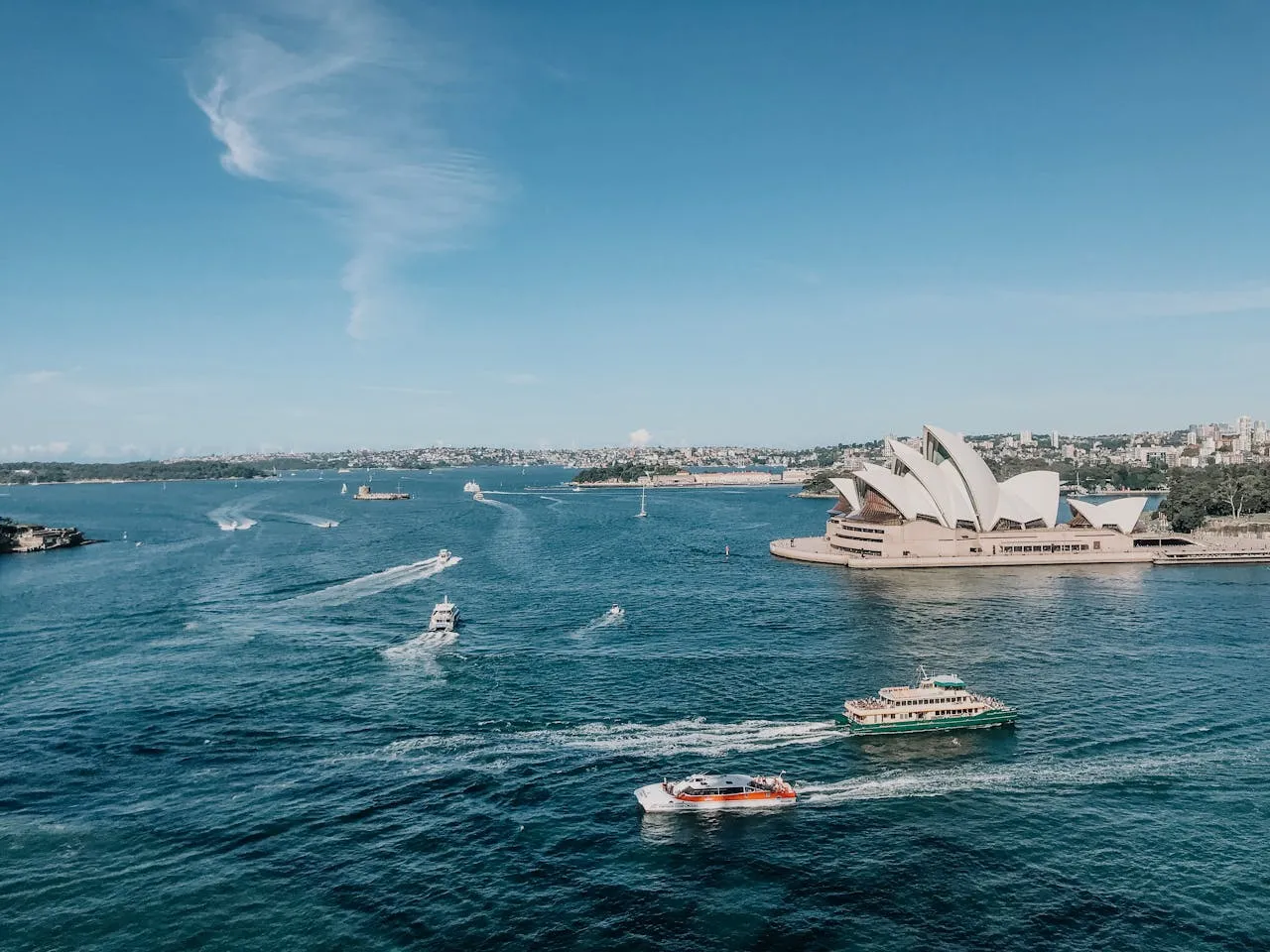 Several boats travelling past Sydney Opera House