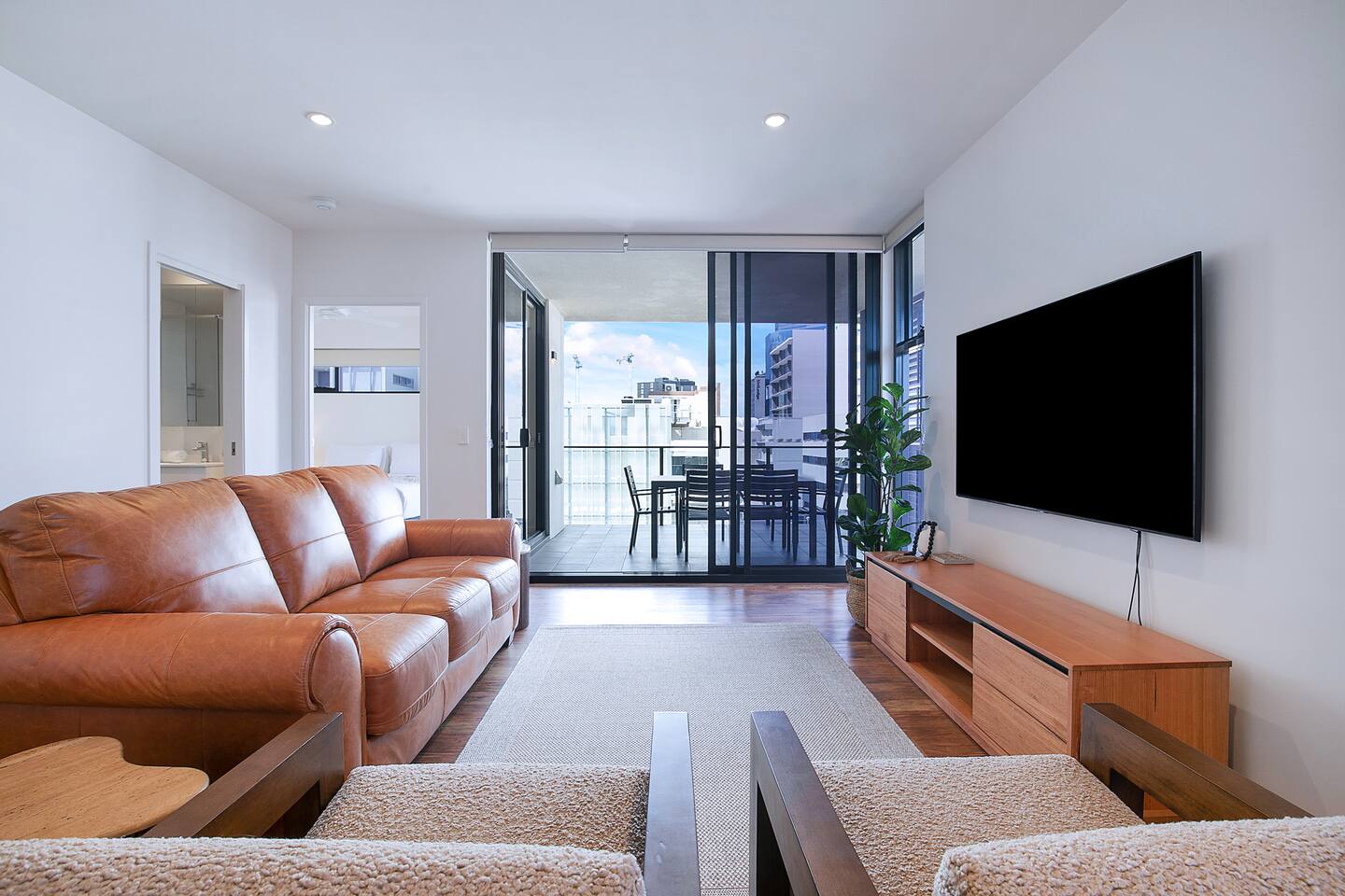 Relax in the living room enjoying a large, wall-mounted TV and comfortable lounge chairs.