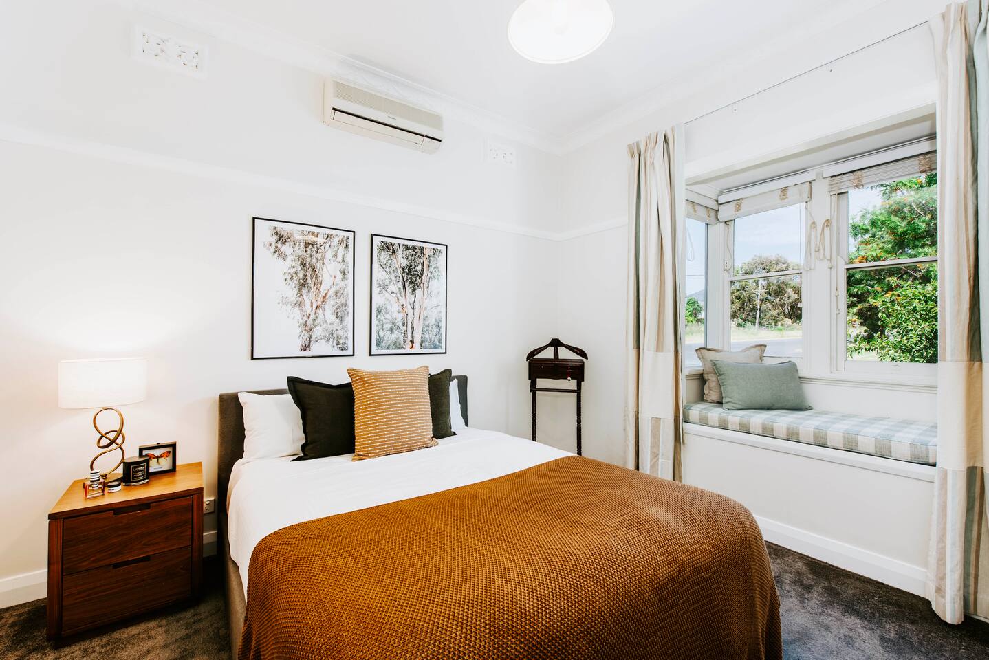 The sumptuous master bedroom is beautifully styled and comes with a queen bed, built-in wardrobe and character window seat.