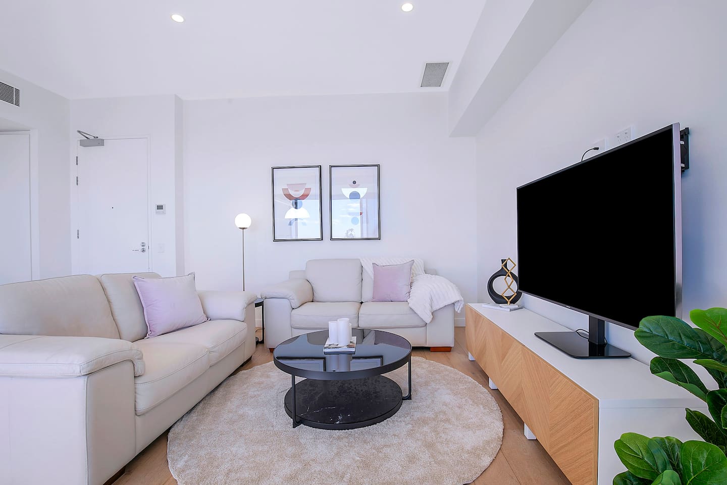 The bright and welcoming living area includes two cosy sofas and a TV, with split system air conditioning and heating ensuring year-round comfort.