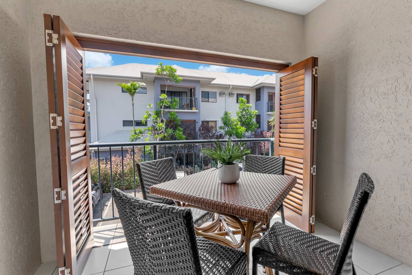 The undercover, all-weather patio features a four-seater table, perfect for alfresco meals and enjoying the tropical ambience.