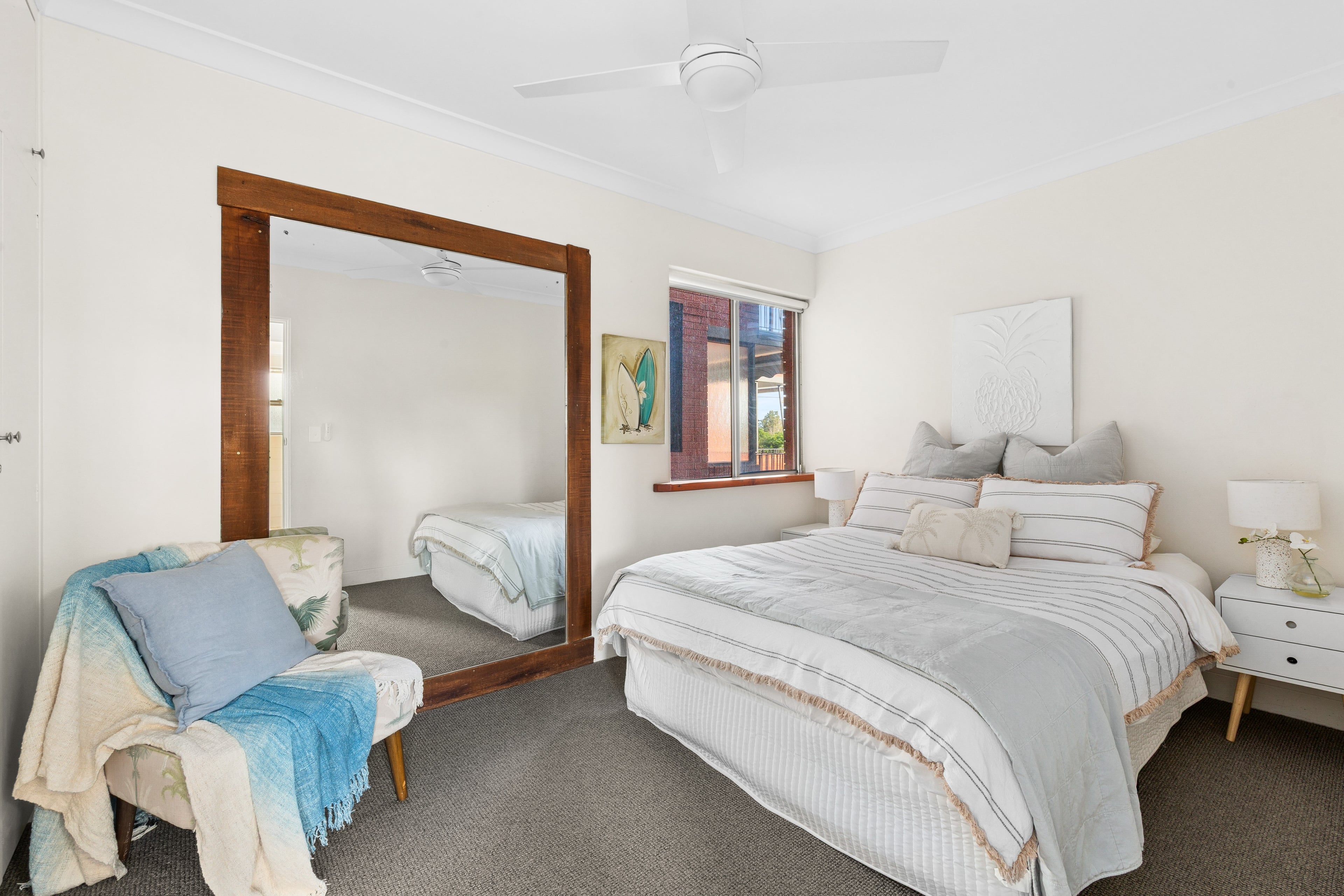 Recharge in the primary bedroom with a queen bed, soft coastal tones, and a quiet corner to settle in at the end of the day.