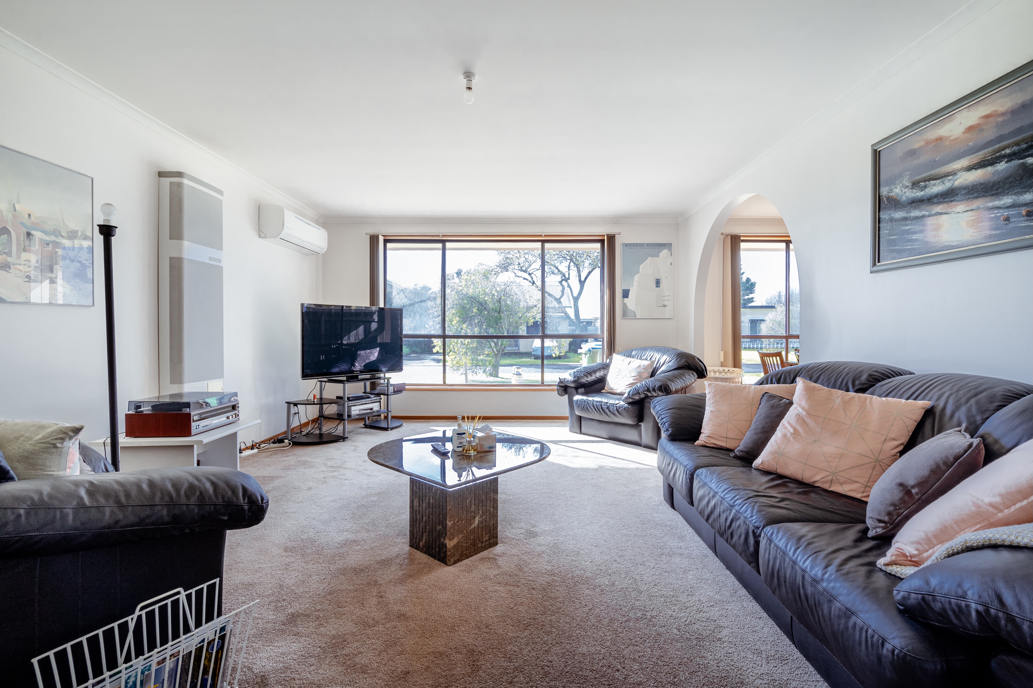 Designed for downtime, the living area pairs generous natural light with comfortable seating, a TV and a record player for leisurely afternoons indoors.