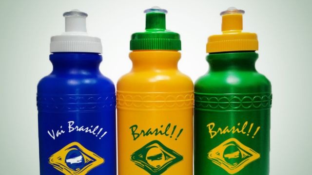 Três garrafas squeeze nas cores azul, amarela e verde, com estampa da bandeira do Brasil.