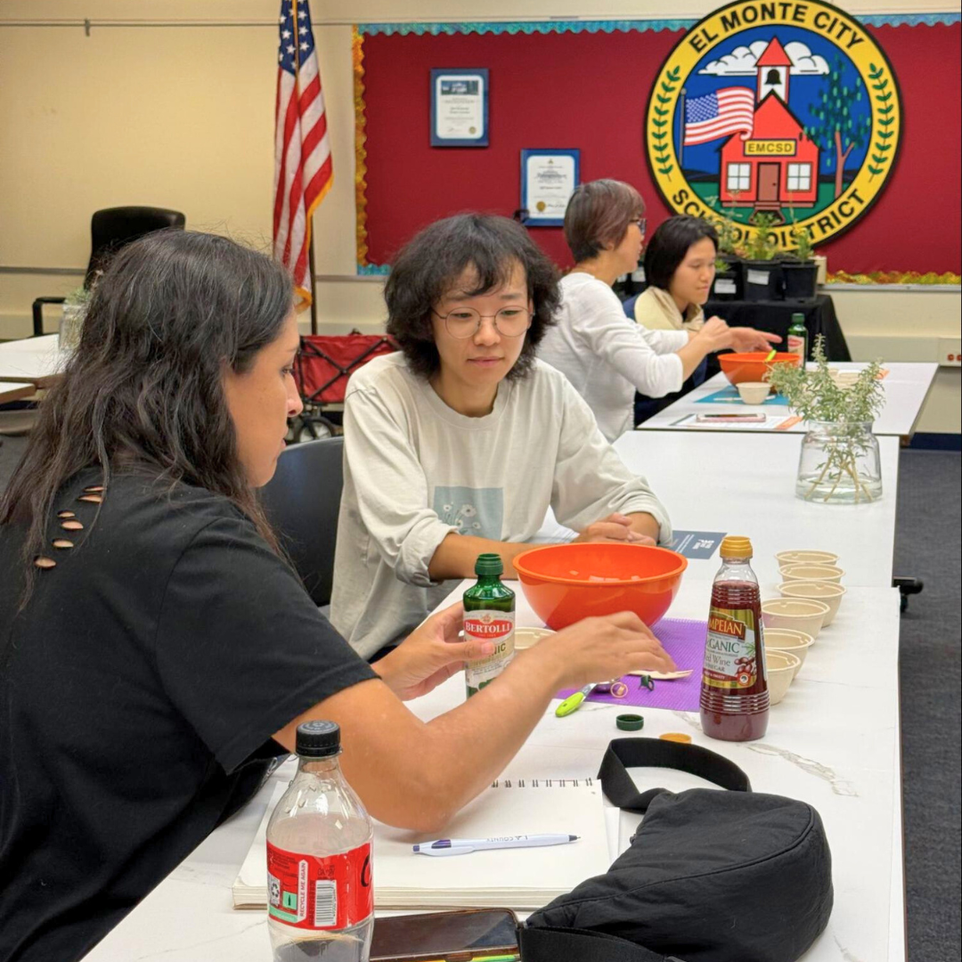 Participants prepare ingredients at a table during a hands-on cooking demo.