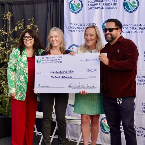 Four people standing behind a large check.