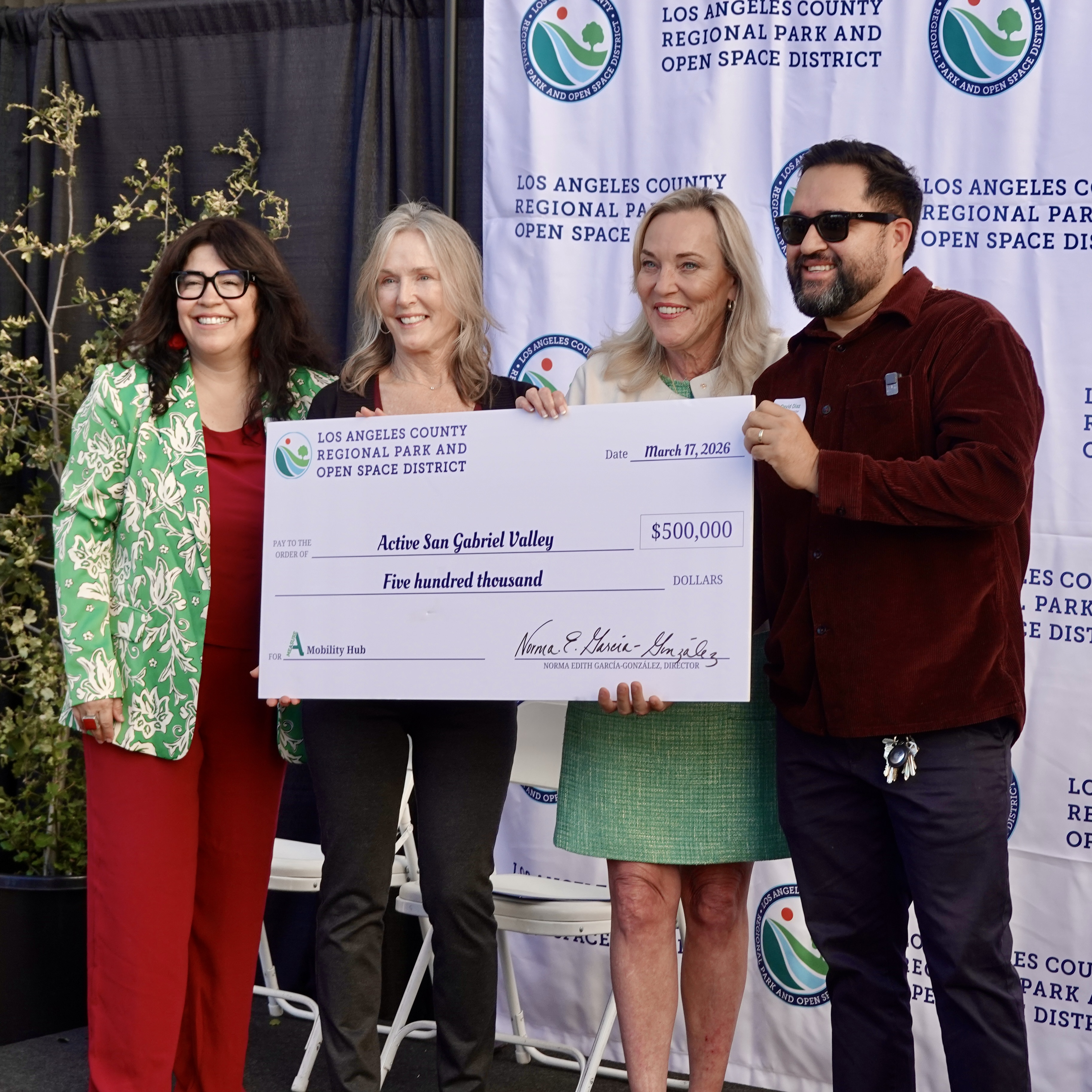 Four people standing behind a large check.