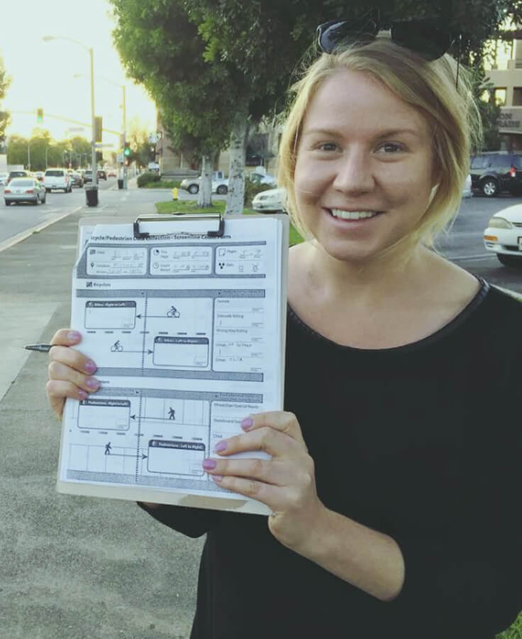A staff member holding a clipboard with transportation data