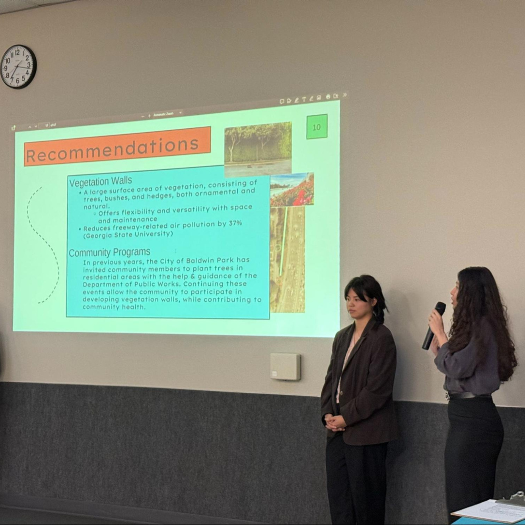 Two participants present findings and recommendations about improving air quality through vegetation walls and community programs.