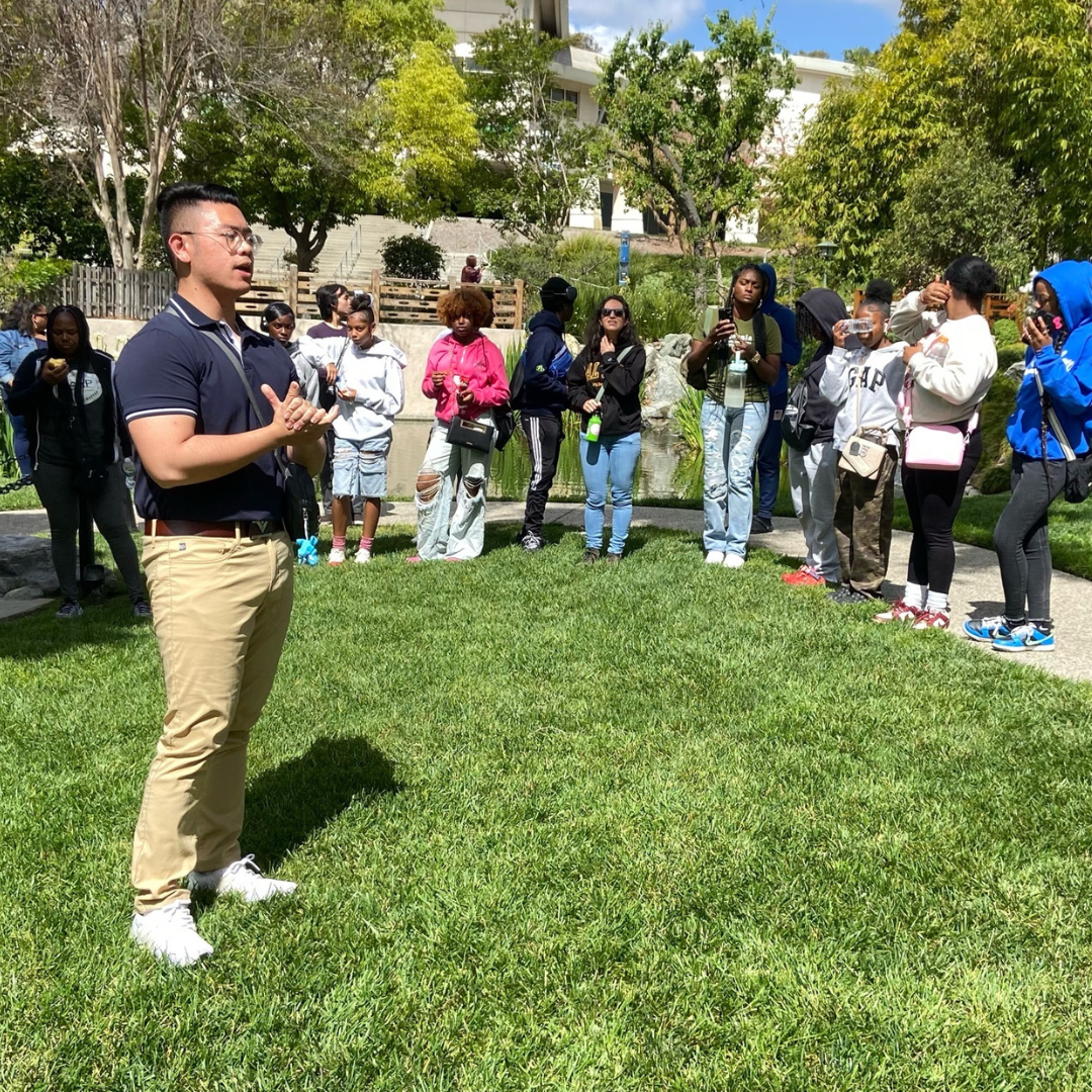 Dat speaks to a group of students during an outdoor educational visit at a landscaped garden