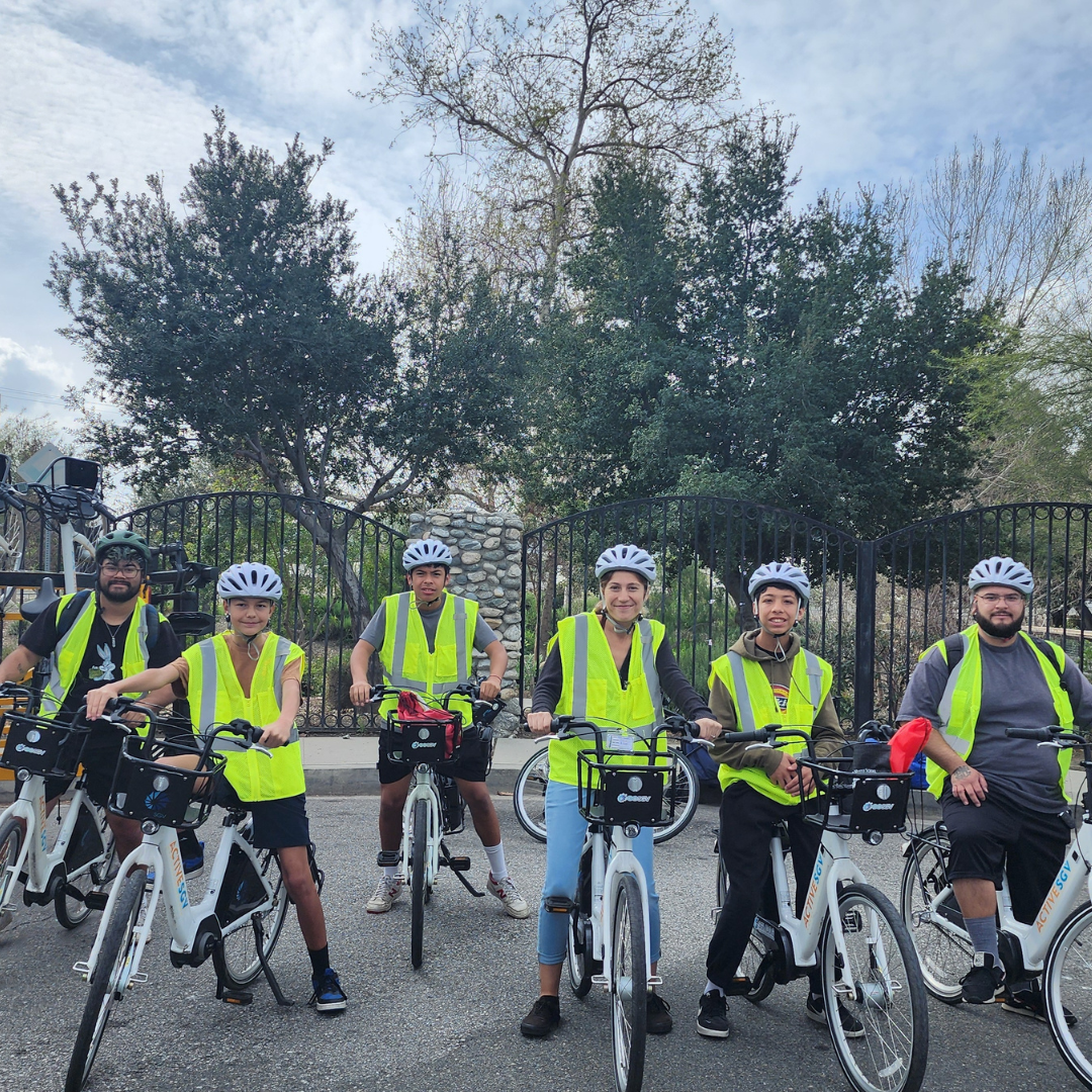 Participants wearing safety vests pose with e-bikes at Easy Access Pop-up.